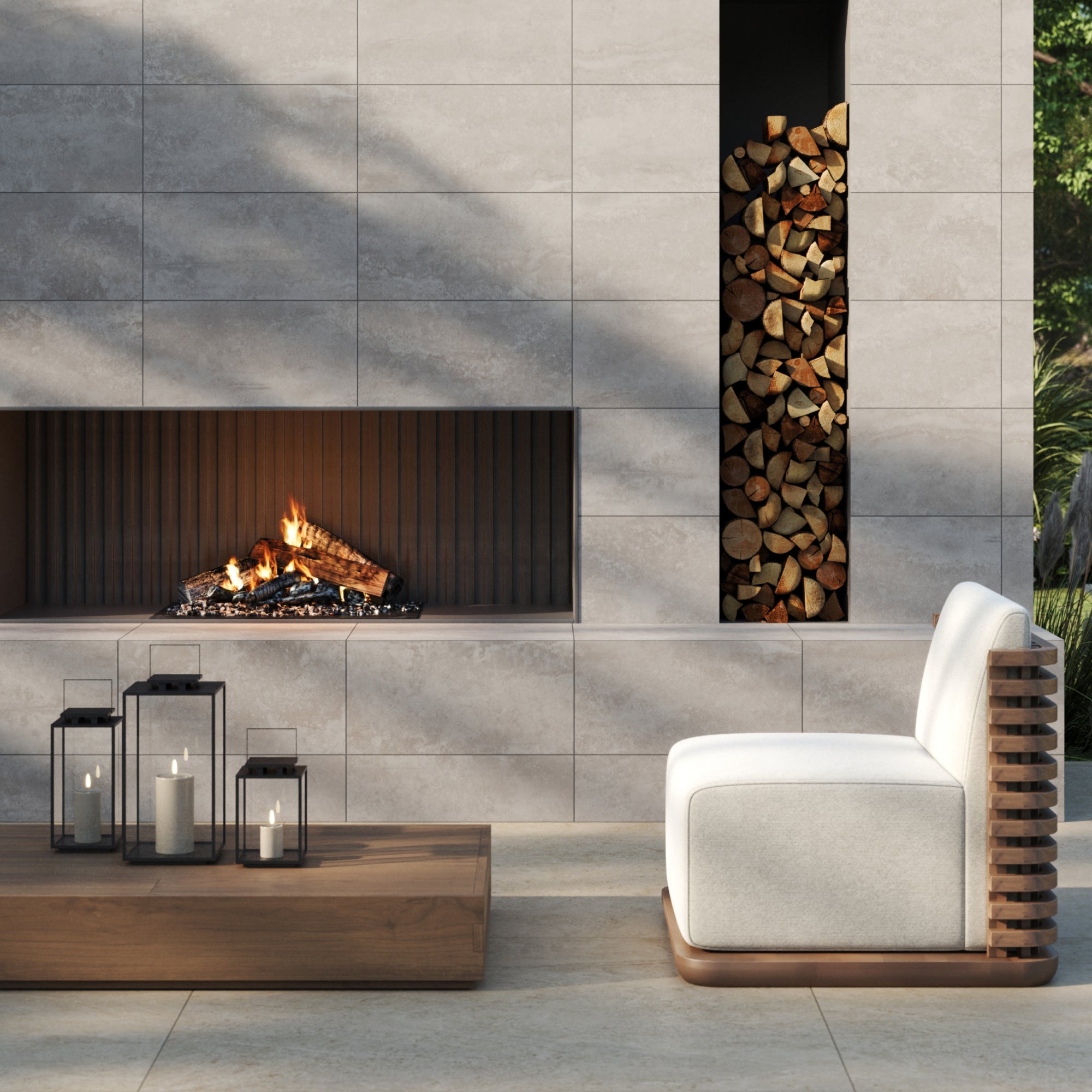 Step into a luxurious modern outdoor space, centered around a contemporary fireplace clad in Pierce 12x24 Matte Porcelain Tile in Stone. The concrete look tiles lend an industrial chic elegance, complementing the natural surroundings while offering a sophisticated, urban touch. Every detail, texture, and shade contributes to a space where modern design and natural beauty coexist seamlessly.