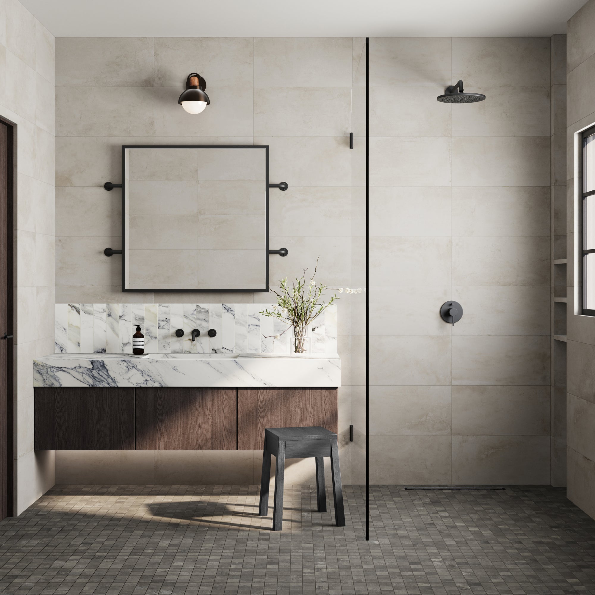 A modern bathroom exemplifies luxury with a skillful fusion of styles. The floor is adorned with 'cement look' Ramsey 2x2 Matte Porcelain Mosaic Tile in Smoke, offering a contemporary, industrial touch. Walls, elegantly draped in Ramsey 12x24 Matte Porcelain Tile in Chalk, harmonize with the vanity, accentuated by the 'marble-look' Aniston 3x12 Polished Porcelain Tile in Calacatta Antico. A symphony of textures and tones, crafting a space where comfort meets sophistication.