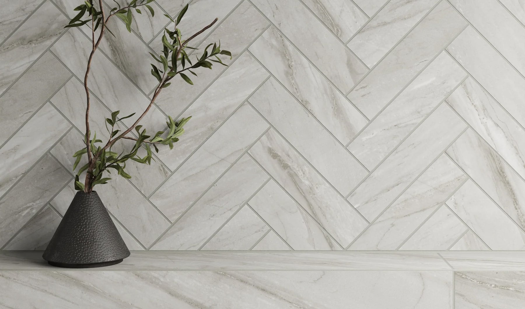 Chic light grey tile in a herringbone design adds a touch of sophistication to this minimalist space