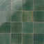 Glossy porcelain square tiles in dark green with a rustic, weathered finish and natural shade variation.