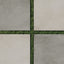 Checkerboard layout of matte 24x24 concrete tiles in ash and chalk tones with green grass growing between the gaps.