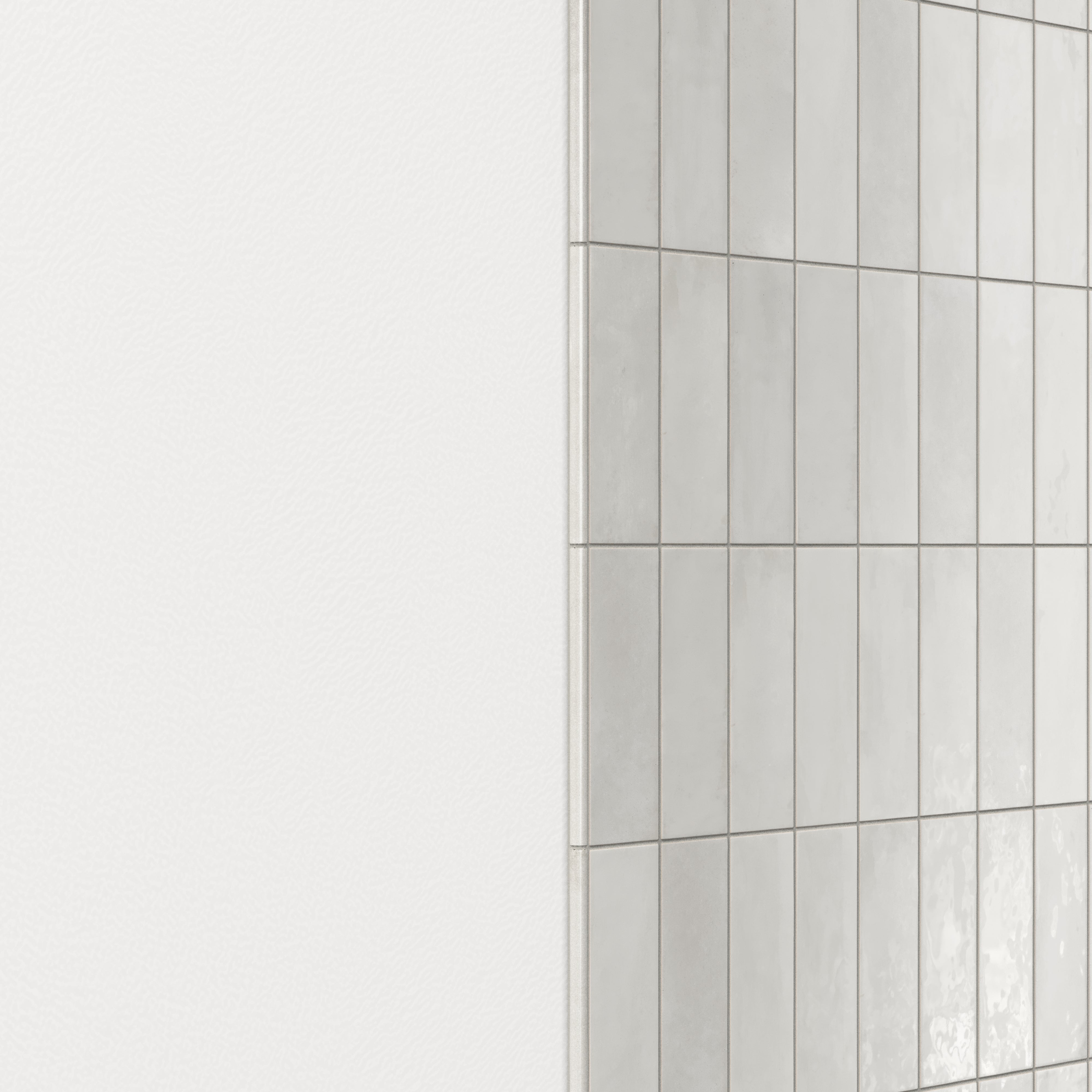 Wall finished with glossy ceramic subway tiles in shifting light gray tones, accented by a rounded tile edge trim for a smooth, polished transition
