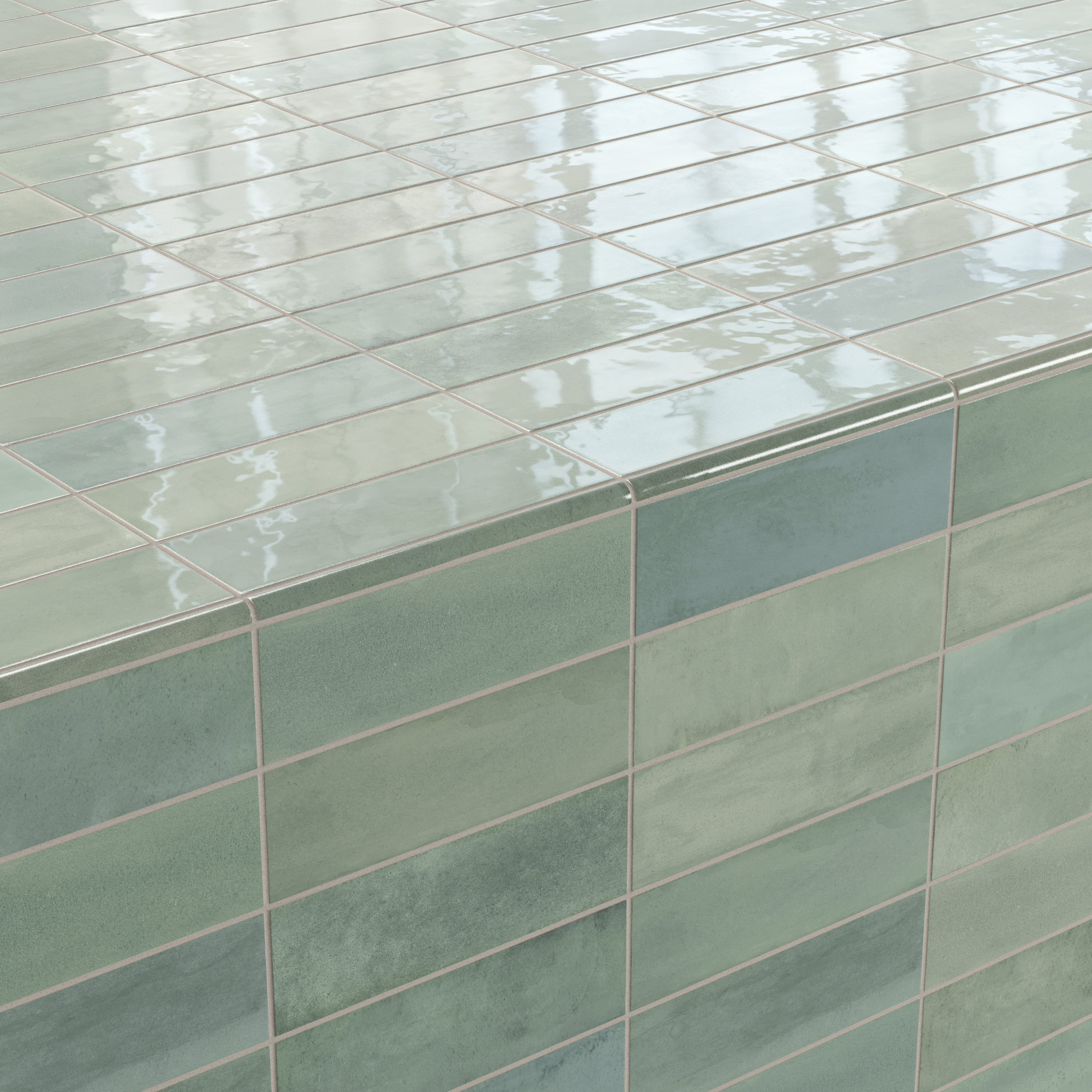 Corner detail of glossy ceramic subway tiles in shifting green tones, finished with a rounded tile edge trim for a smooth and seamless transition