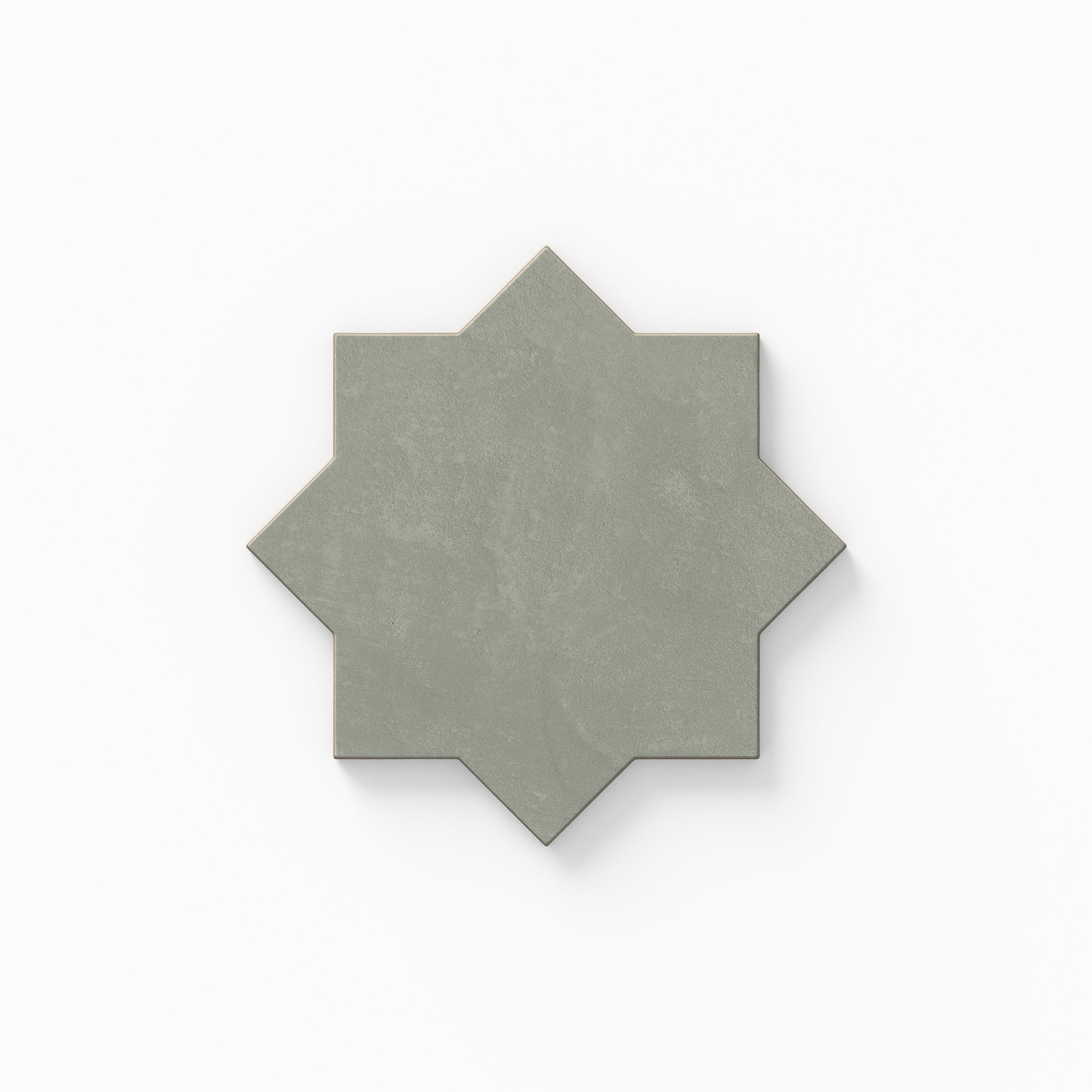 A decorative eight-point star tile from our Isabel 11x11 Matte Porcelain Star and Cross set, featuring muted sage green tones with subtle cement-plaster texture and a soft, powdery aged finish.