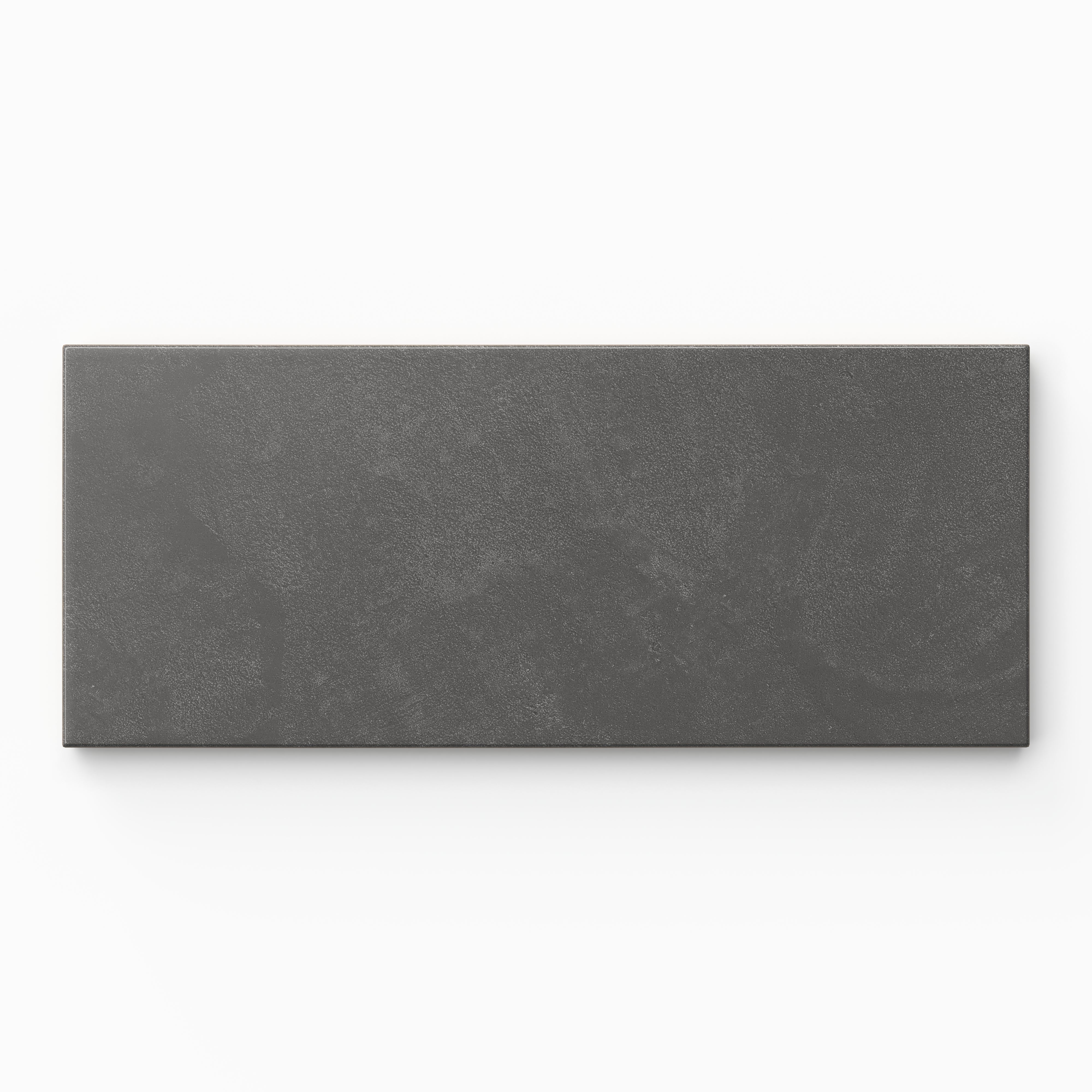 Isabel 2.5x12 Matte Porcelain Tile in Charcoal shows earth-drawn dark gray shading with quiet movement, finished with a powdery glaze and gentle cement-plaster texture.