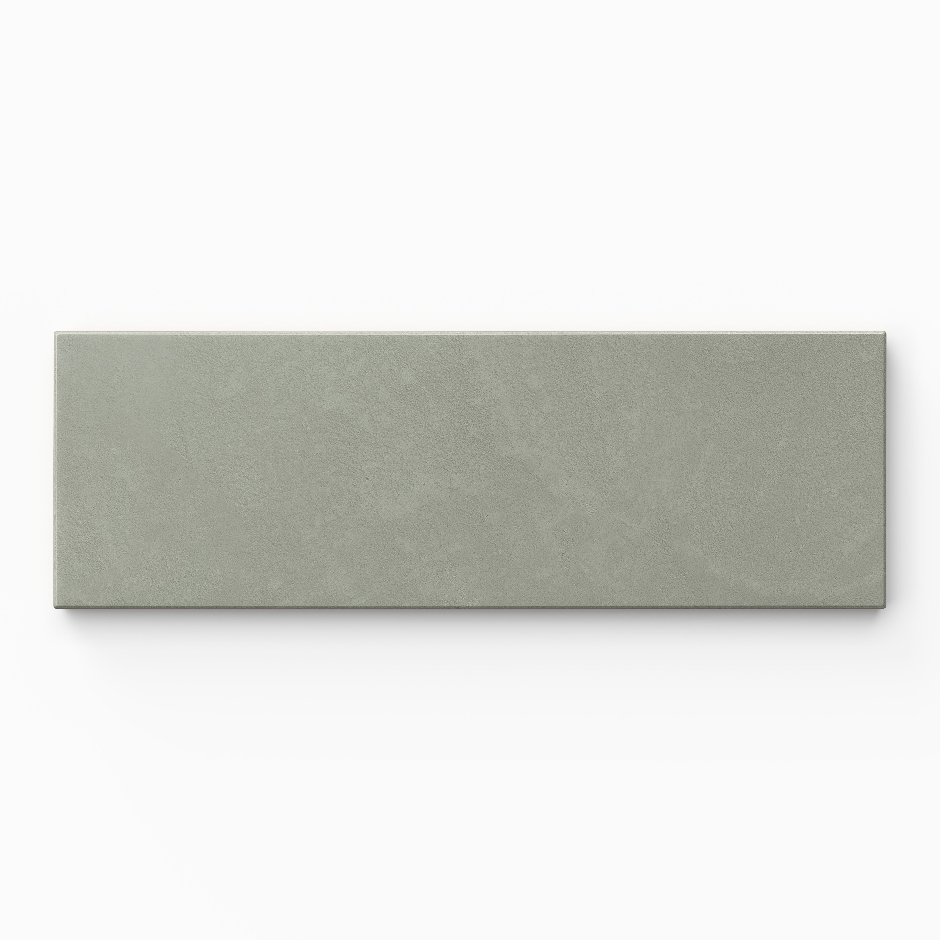 Isabel 2x6 Matte Porcelain Tile in Seasalt shows a powdery matte finish with gentle sage green tones and a lightly textured cement-plaster surface.
