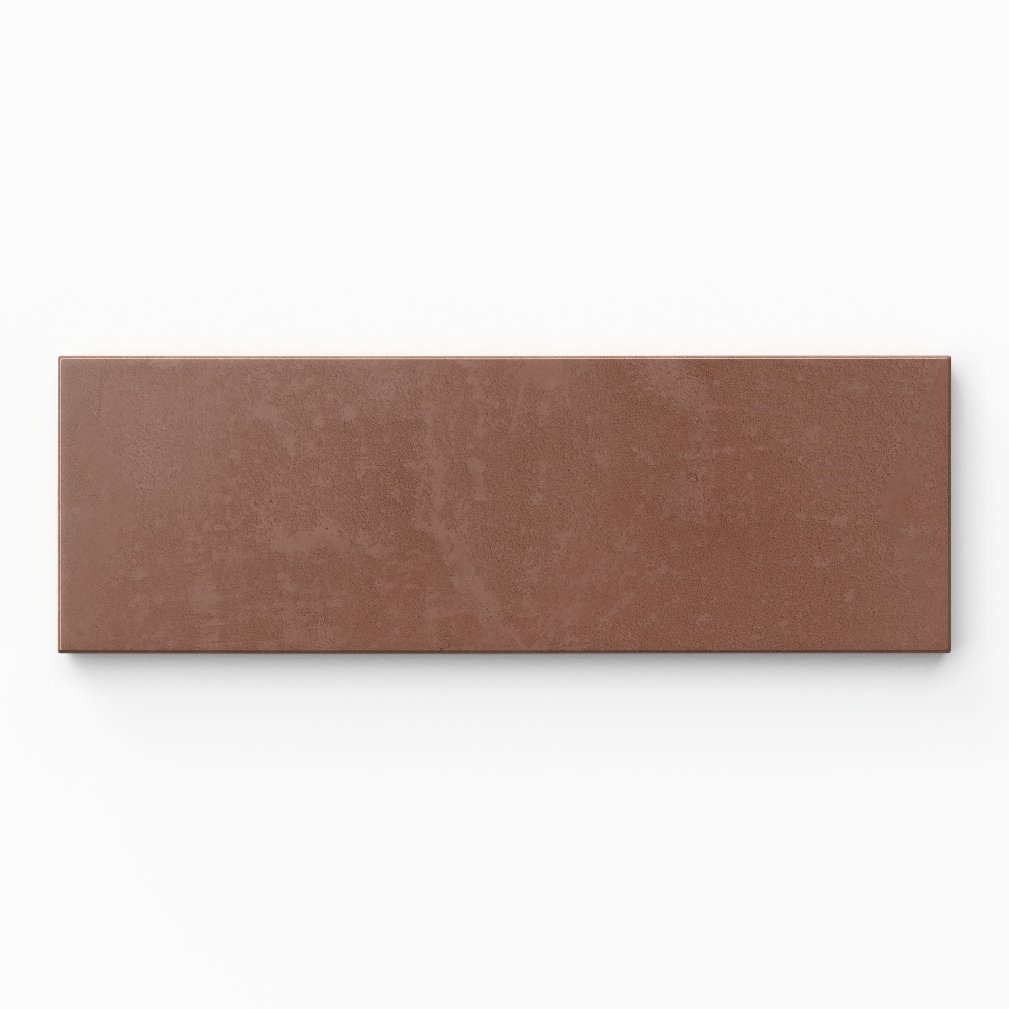 Isabel 2x6 Matte Porcelain Tile in Rust displays a tactile matte surface with cement-plaster texture and earth-drawn red tones, suited for warm, character-driven wall designs.