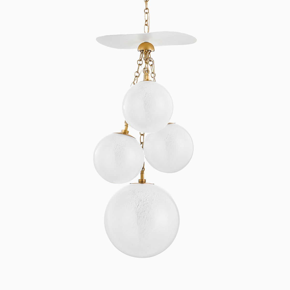 Pendant light in vintage brass featuring four frosted glass globes of varying sizes, suspended from brass chains and canopy.
