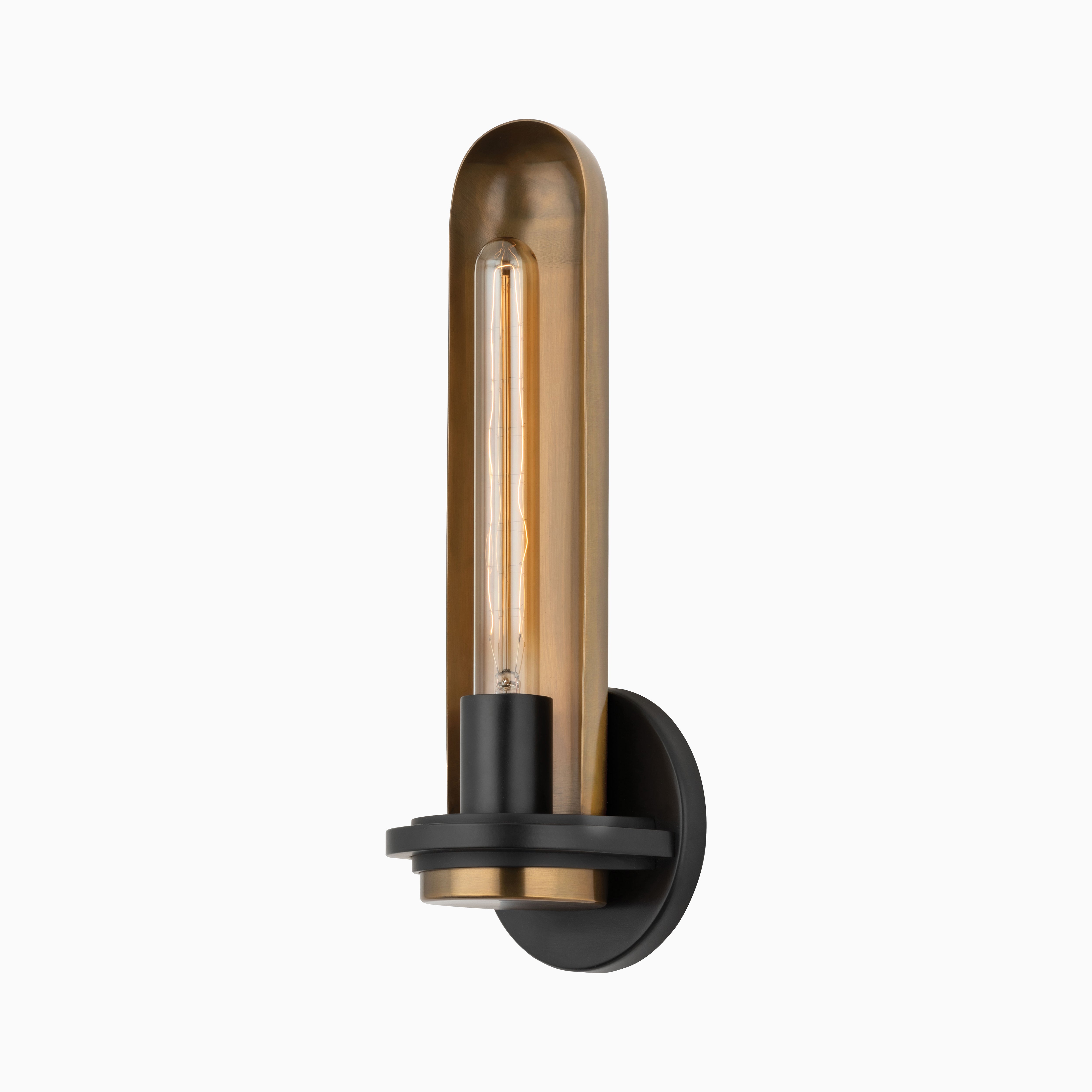 Patina brass wall sconce with rounded vertical shade, exposed bulb, and black backplate, showcasing modern industrial design.