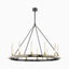 Industrial-style ring chandelier in black and brass with vertical tubular bulbs, suspended by slim rods for a dramatic focal point in modern interiors.
