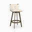 Swivel counter stool with tufted off-white leather seat, low backrest, and angular brushed brass base with a circular footrest.
