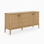Wooden sideboard with patterned front detailing, bronze pull handles, and elevated frame for a sleek yet organic aesthetic.