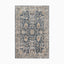 Power loomed area rug made of polypropylene and polyester, featuring an intricate Persian-inspired pattern in distressed navy, beige, and ivory tones for a timeless look.