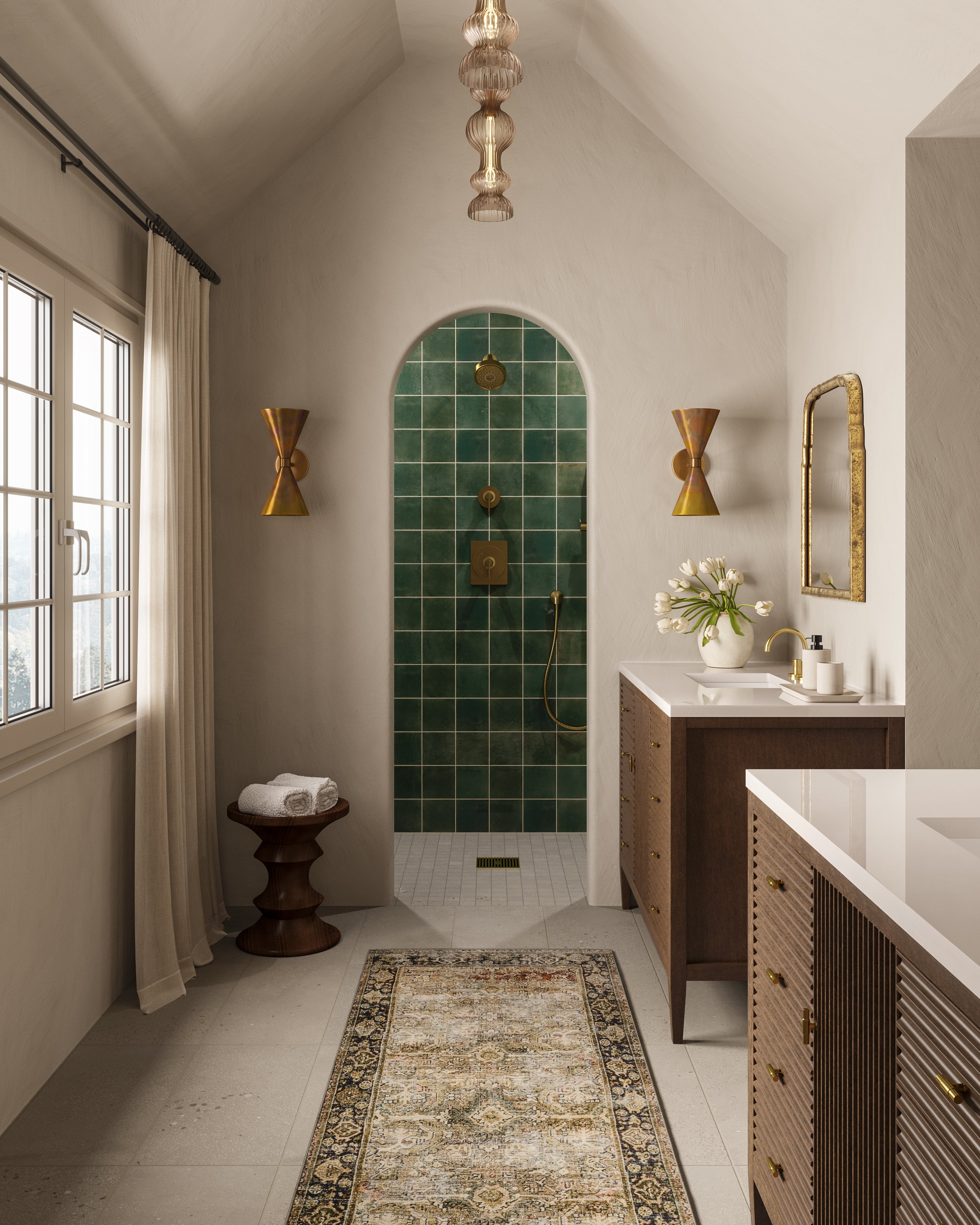 Bathroom with a dark green tiled shower featuring a rustic finish, paired with a wood vanity, brass accents, and neutral walls.
