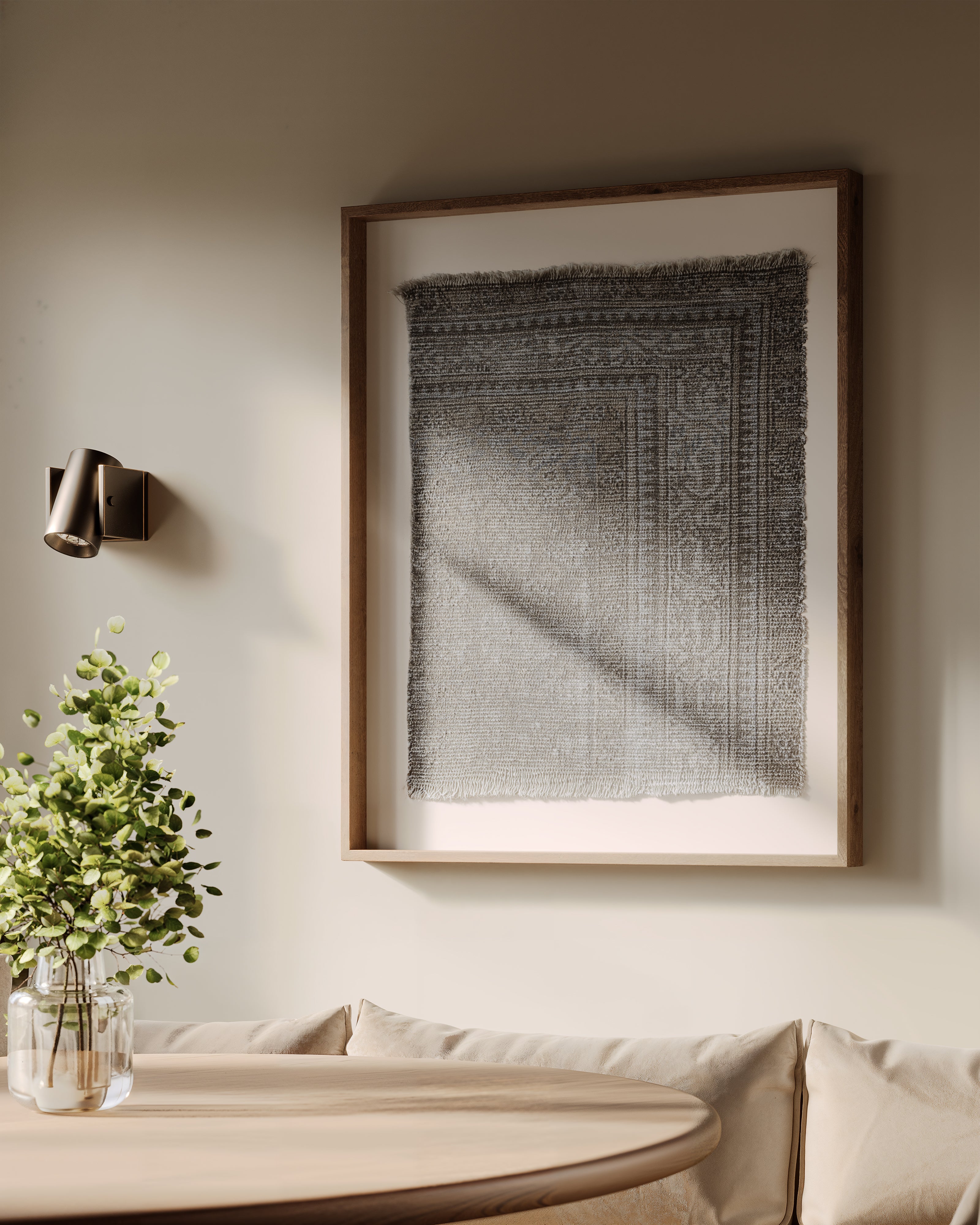 Neutral dining nook featuring framed textile wall art with soft gray tones, paired with warm wood accents, greenery, and ambient lighting.