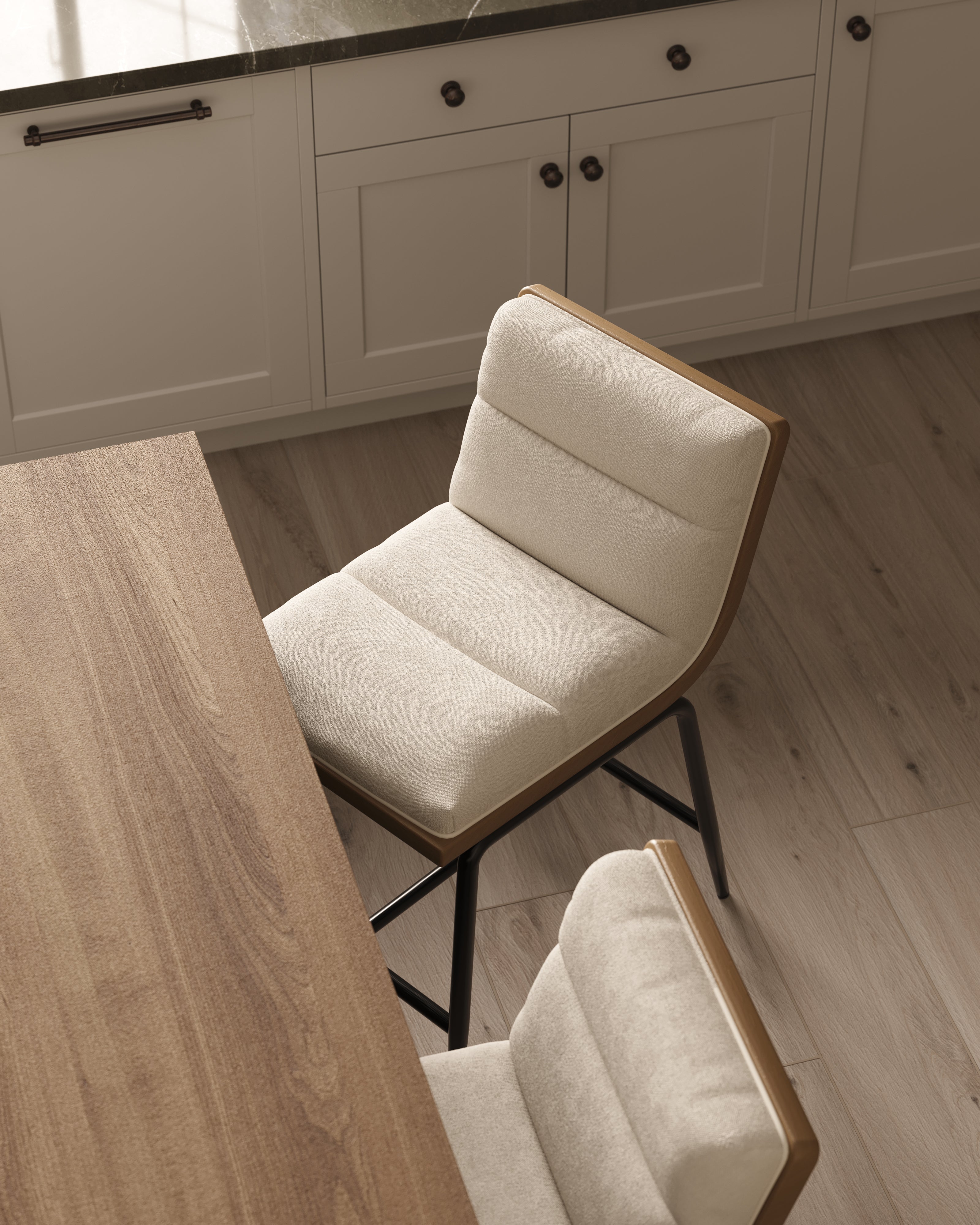 Counter stools with plush channel-tufted seats and sleek black bases balance comfort with style, echoing the natural wood tones of the island in this modern kitchen.