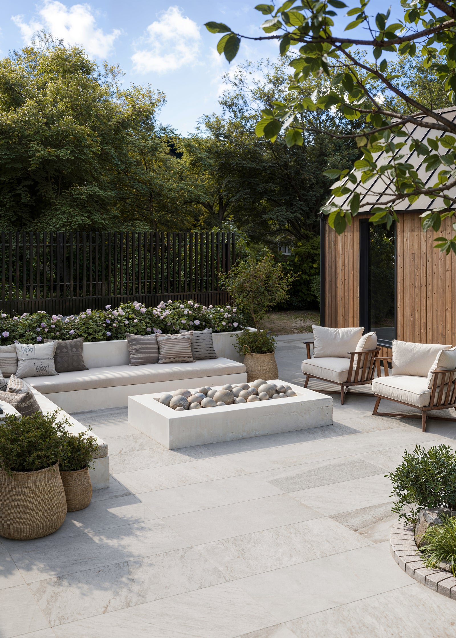 Spacious patio design using Carter Stone 24x48 Matte Pavers in 2cm thickness, complemented by natural surroundings and a cozy lounge area.