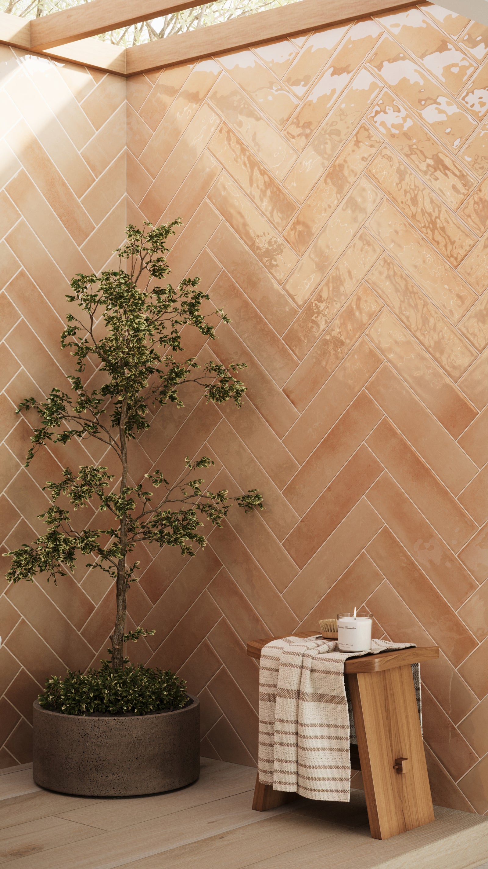 Orange glossy subway tiles in a herringbone layout add warmth and texture, complemented by natural wood tones and greenery for a tranquil setting.