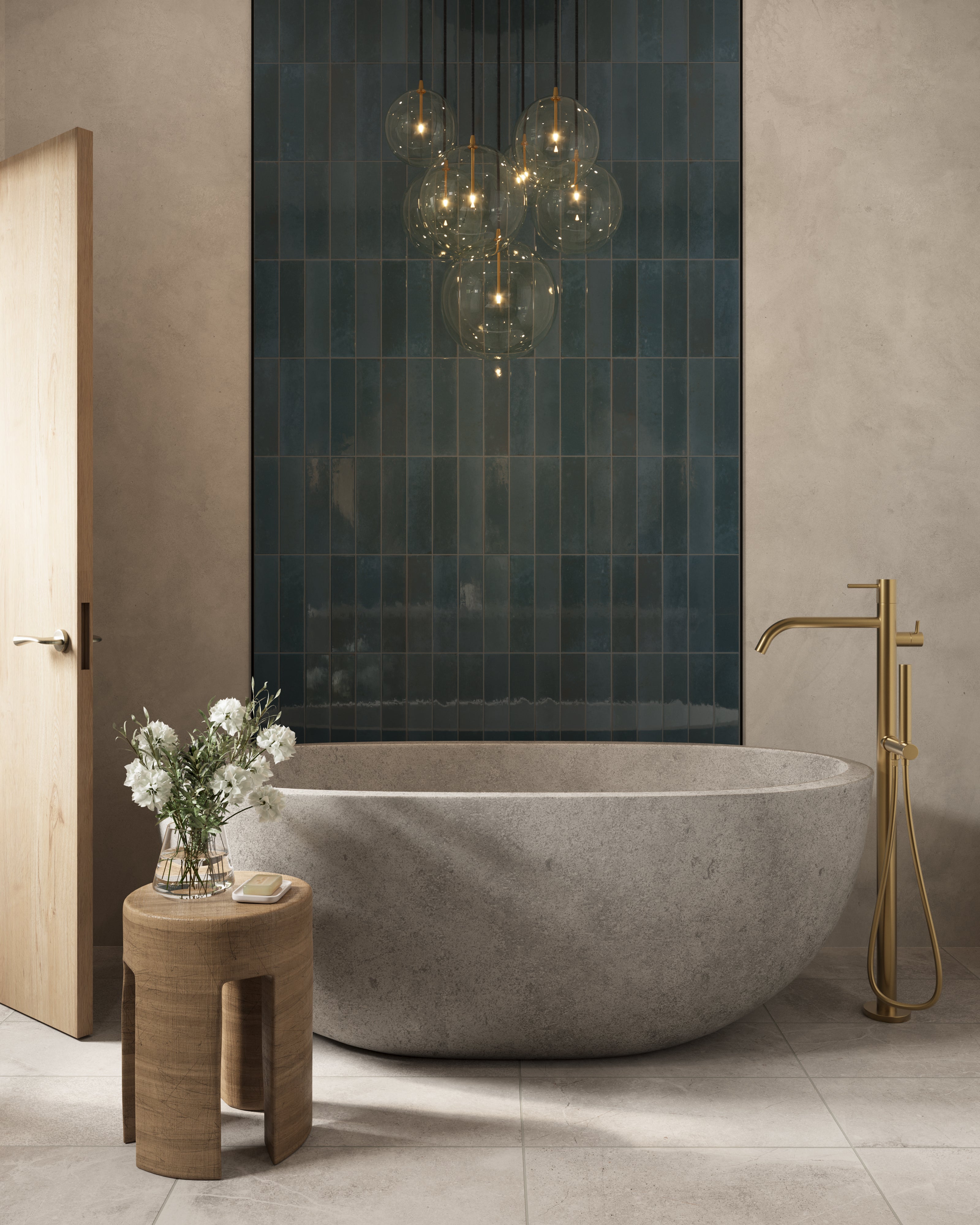 Freestanding stone tub with brass floor faucet, glass globe chandelier, and deep blue tile accent wall in a serene modern bathroom