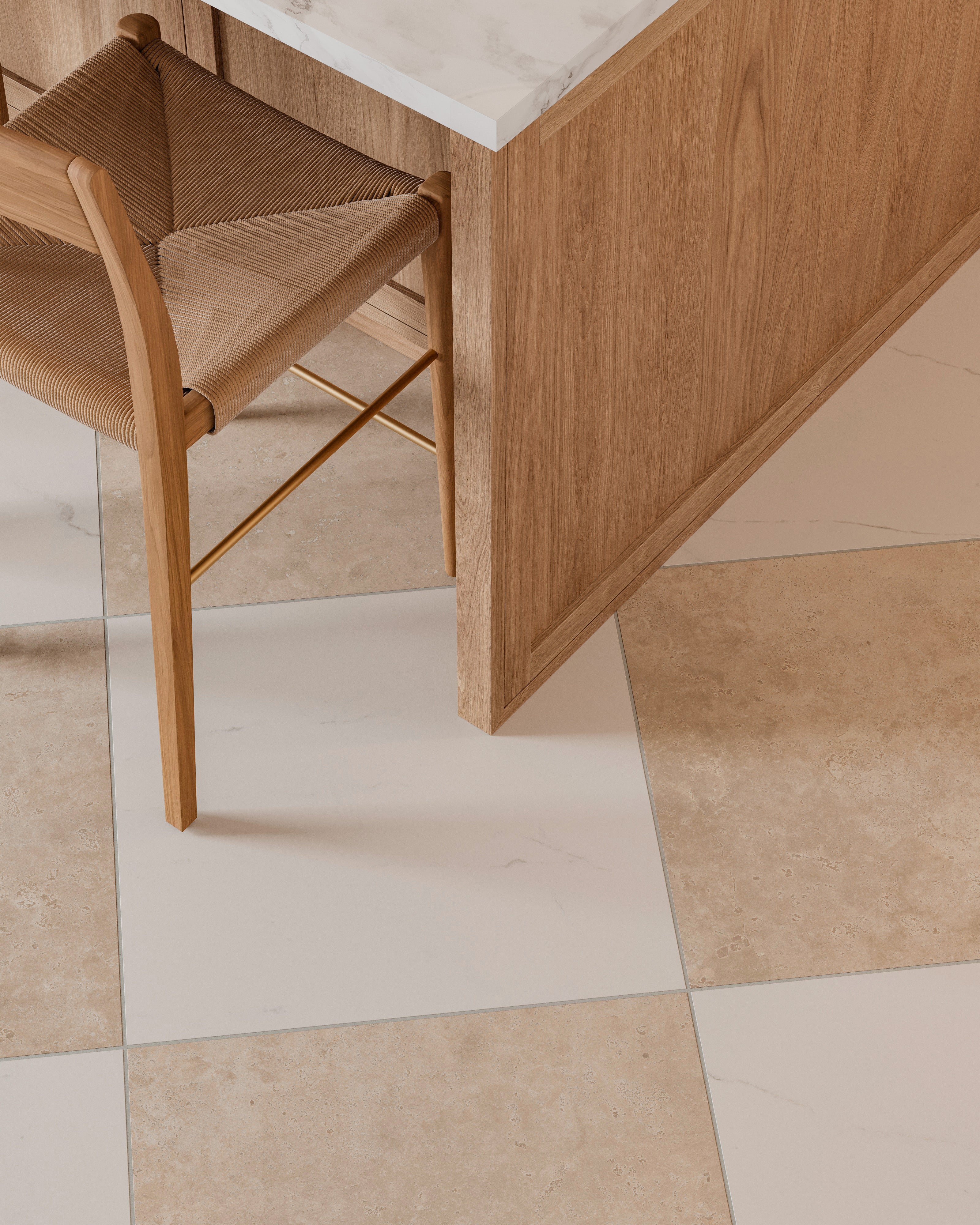 Close-up of a woven seat bar stool tucked against a light wood island with marble top, resting on beige and white checkerboard tile flooring.