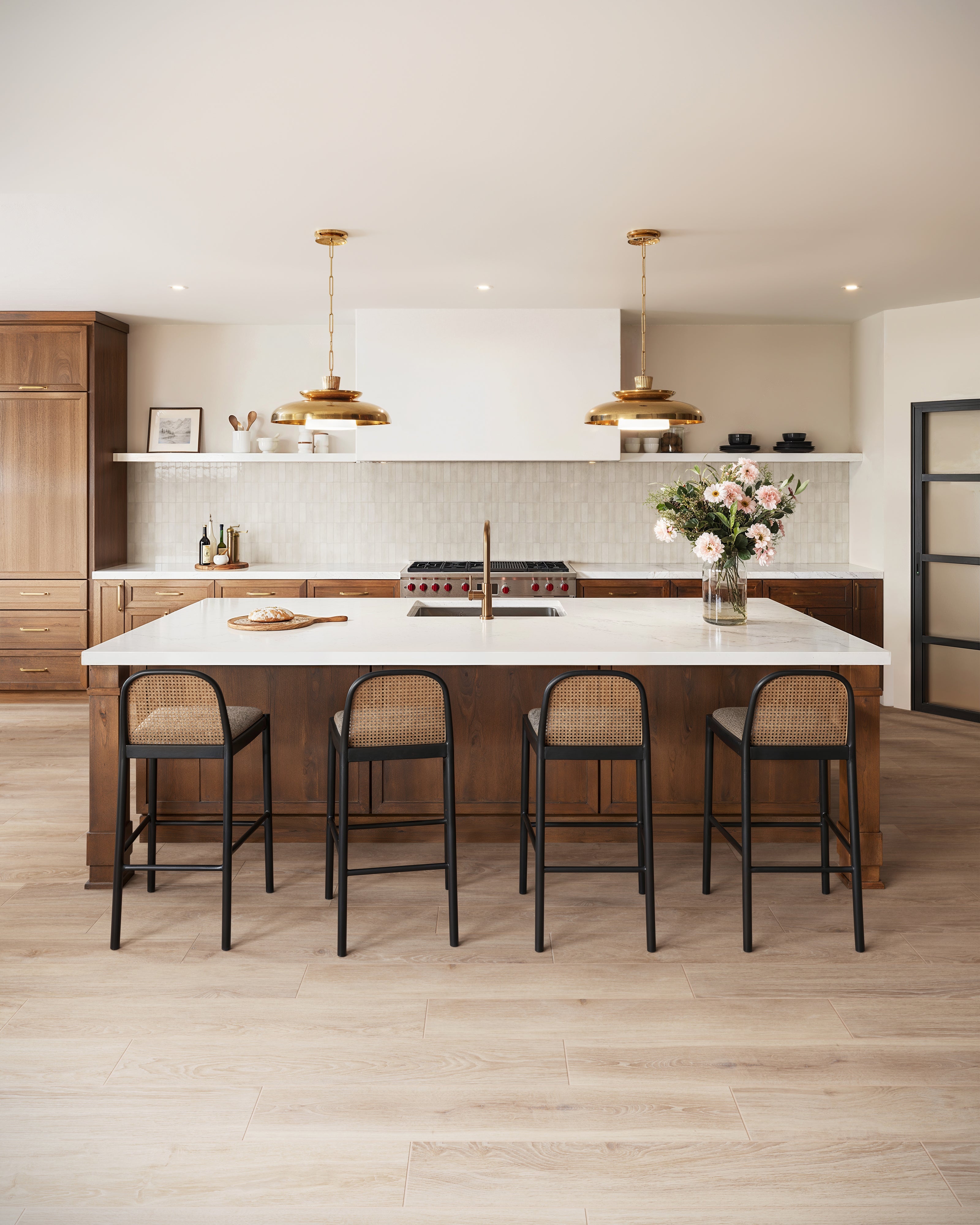 A kitchen with taupe tiles as backsplash and wood look tiles, bringing a warm and natural feel.
