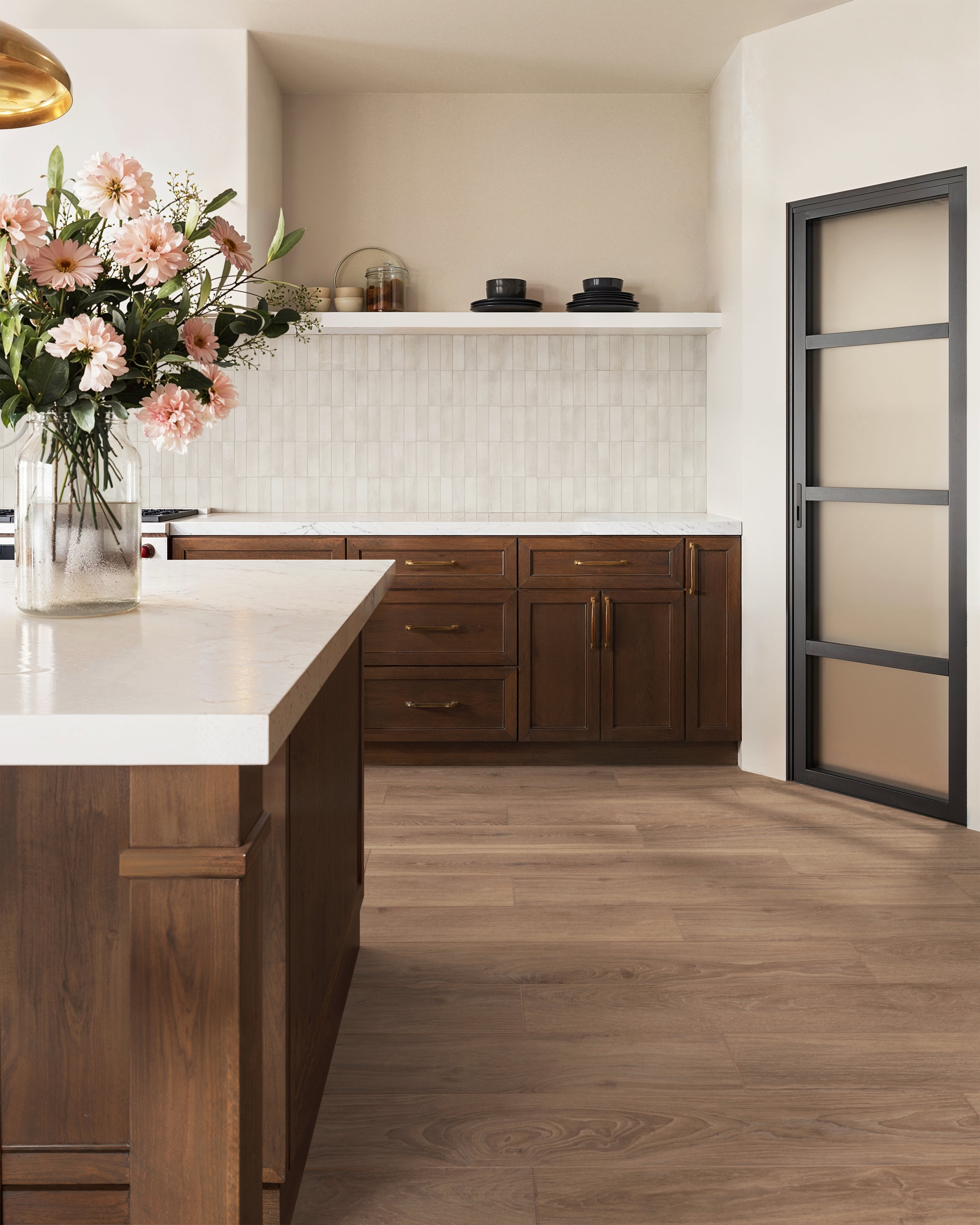 The backsplash showcases soft taupe tiles with a subtle gloss finish, creating an inviting backdrop that complements the warm wood cabinetry.