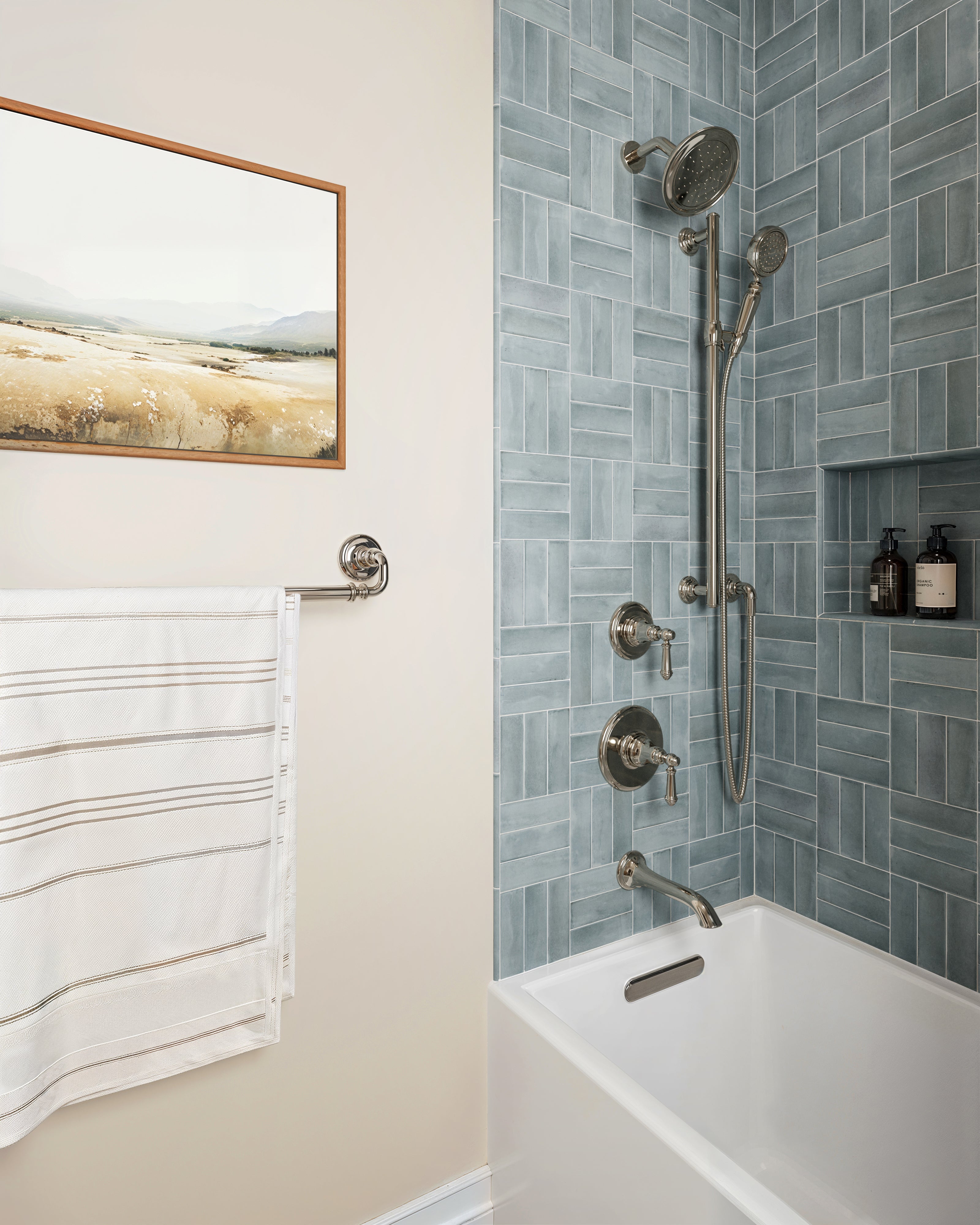 Shower surround clad in Natasha 2x6 matte porcelain tile in Ice,  boasting a soft blue tone, laid in a basketweave pattern for a refreshing and refined spa-like appeal.