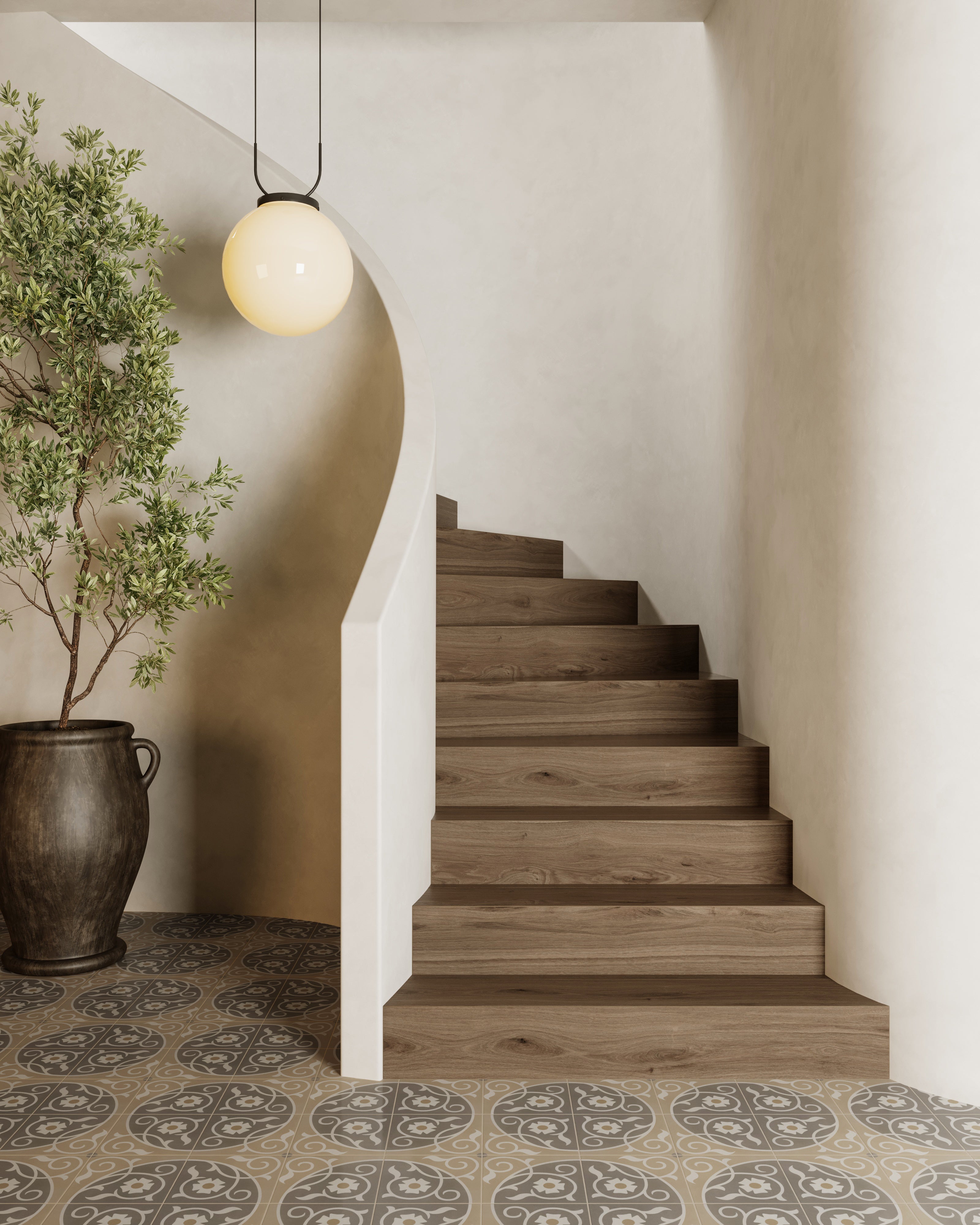 Staircase with wood steps, curved plaster wall, potted plant, globe pendant light, and Brielle Florian 8x8 matte porcelain tile flooring.