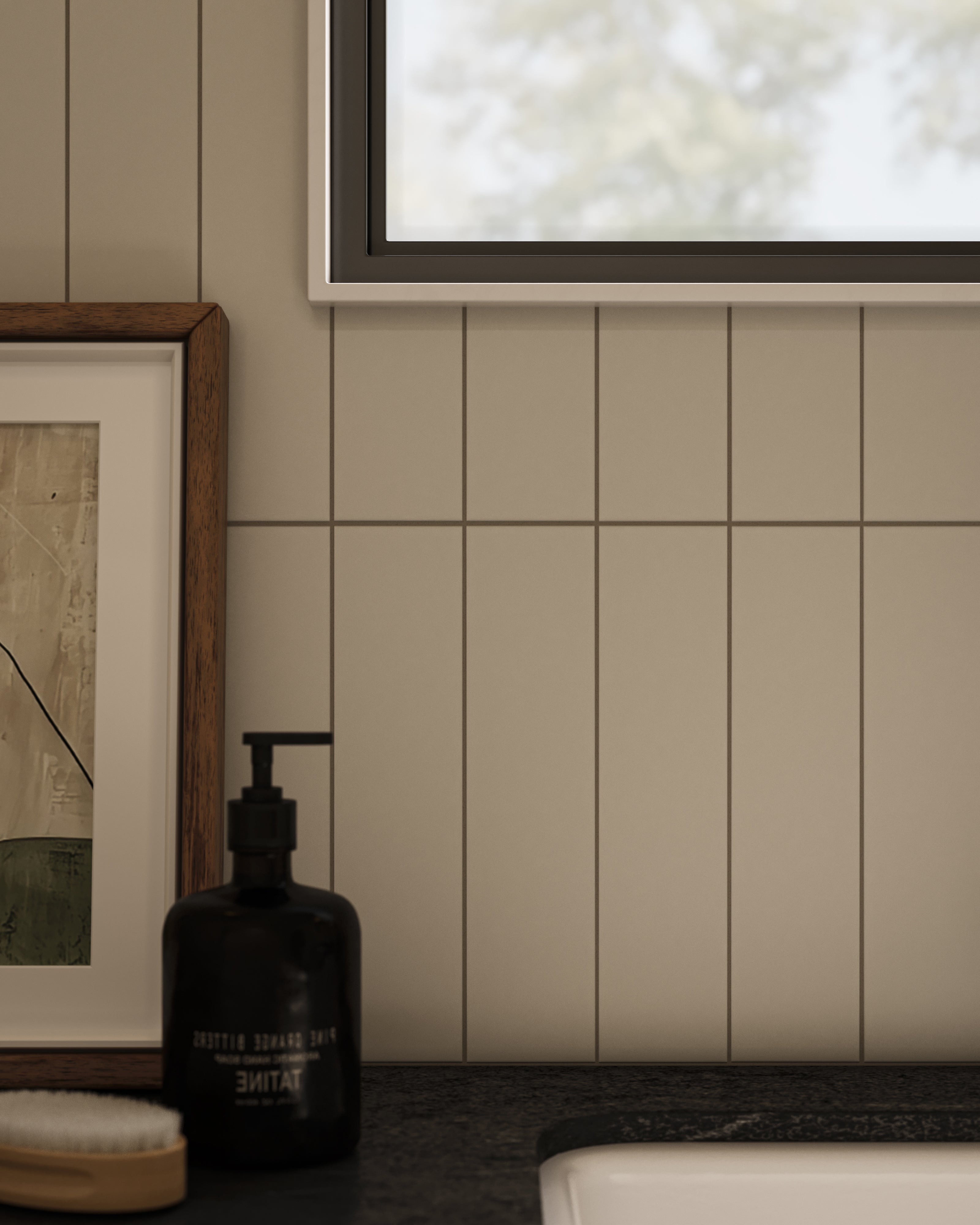Close-up of vertical off-white subway tile wall with fine grout lines, paired with a black stone countertop and matte black soap dispenser for a clean, modern look.