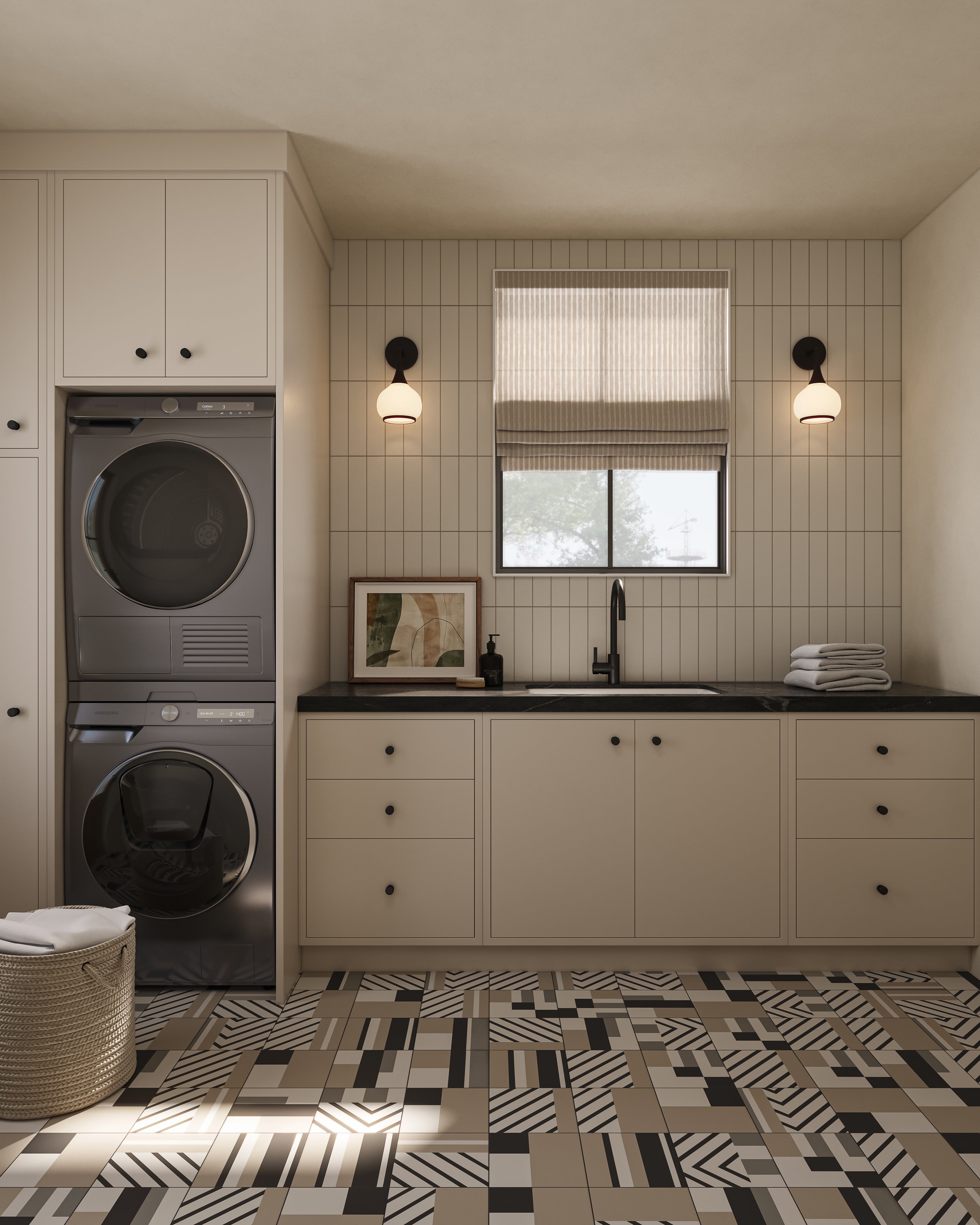 Modern laundry room with stacked washer and dryer, beige cabinets, black countertop sink, patterned geometric tile floor, and matte black wall sconces flanking a window with a Roman shade.