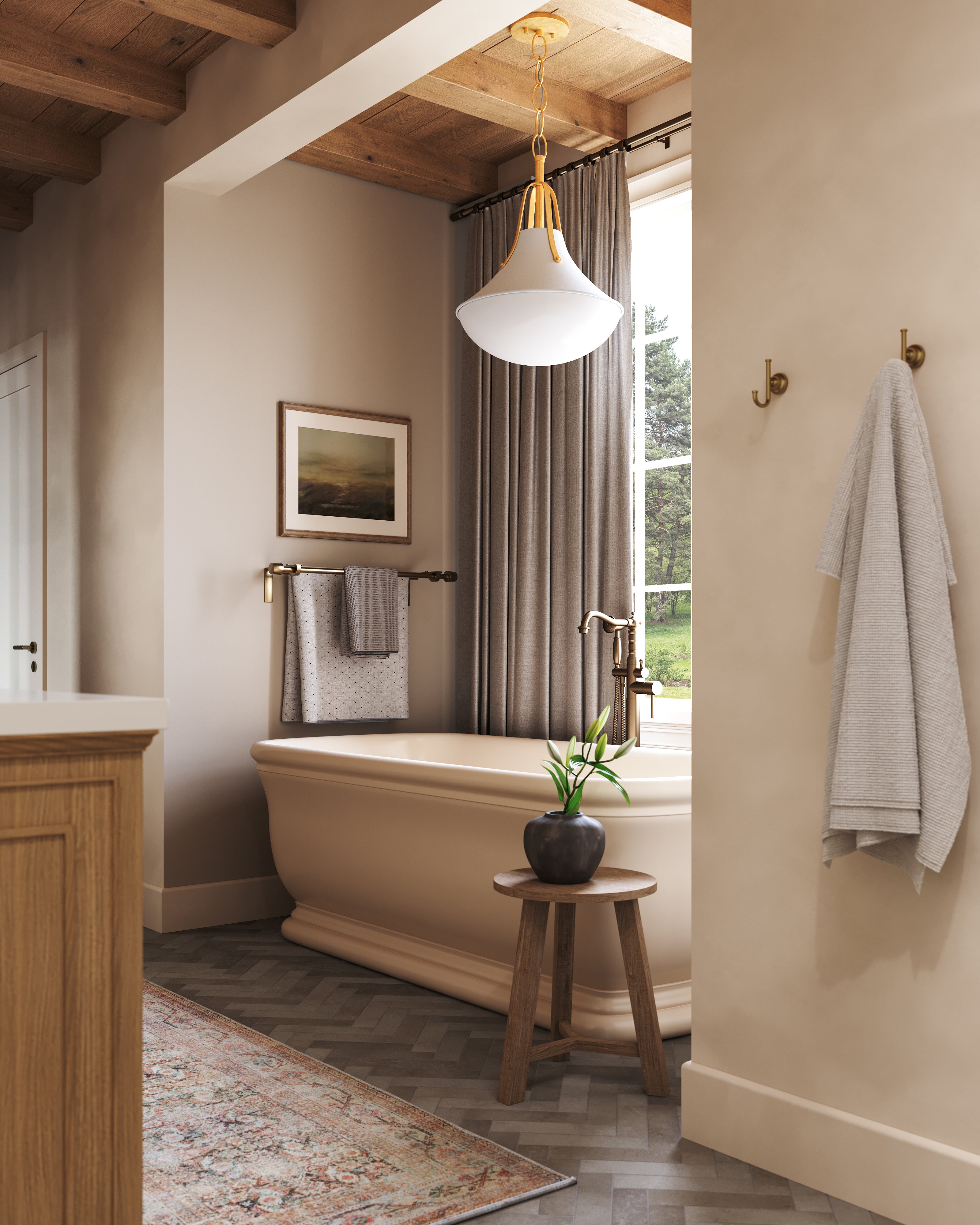 Vintage gold leaf pendant light with a sculptural flared shade and frosted diffuser suspended by a brass chain, casting warm ambient illumination over a classic freestanding tub in a soft, beige-toned bathroom.
