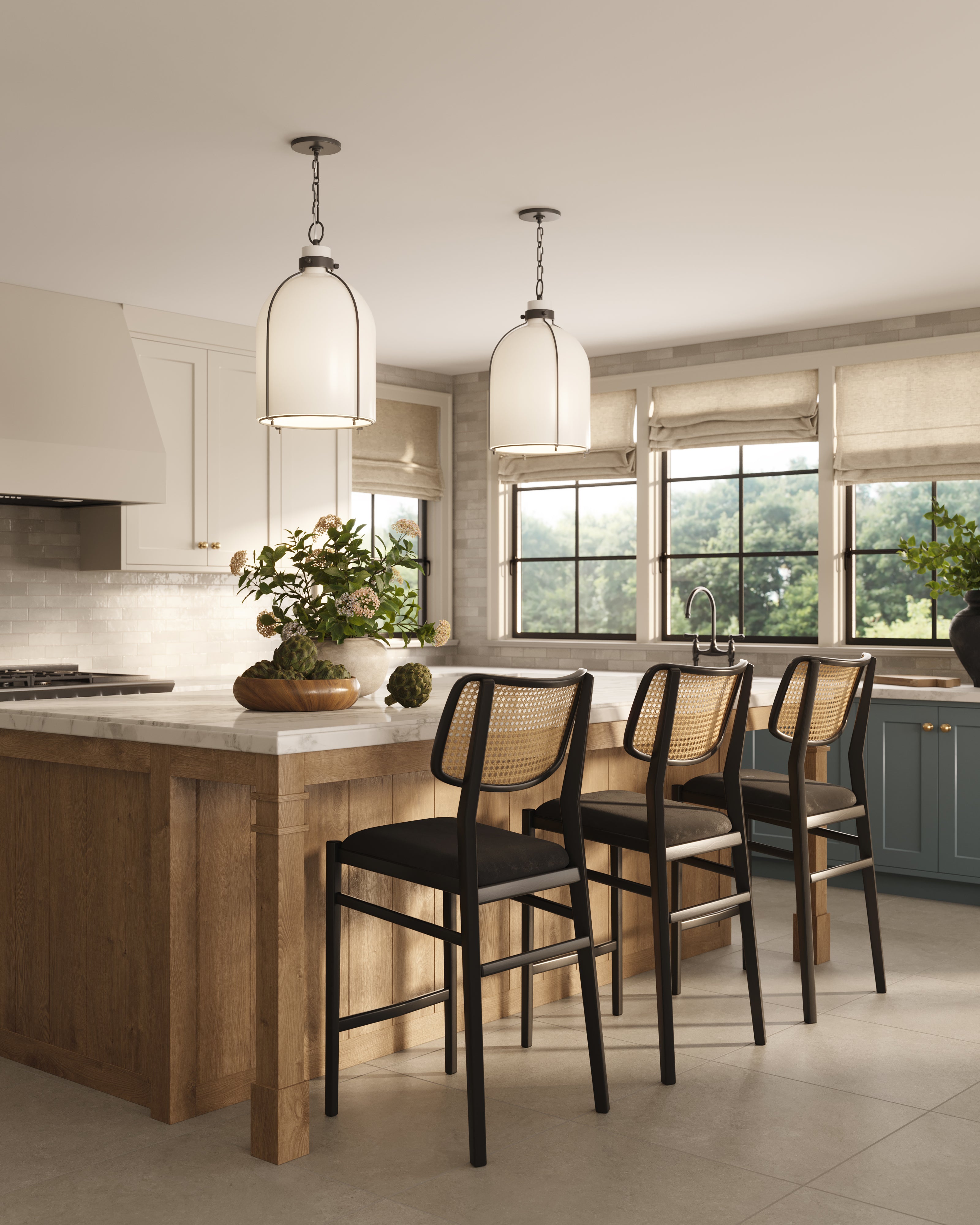 Kitchen island with cane-back counter stools in black wood frames, styled with a marble countertop, wood paneling, and oversized pendant lighting.
