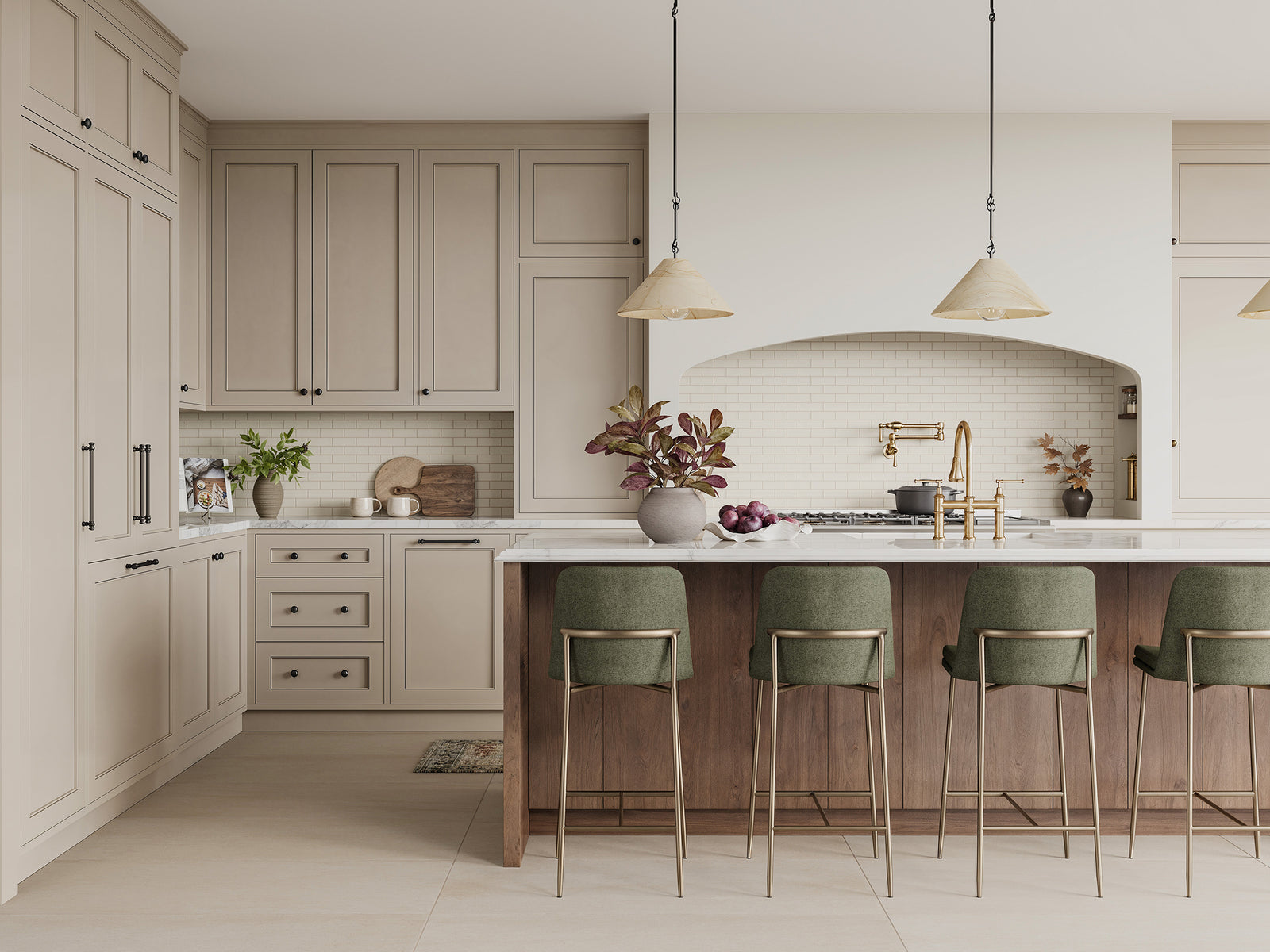 Four counter stools in deep green fabric with gold legs lined along a marble island, creating a rich contrast against the wood tones and light kitchen finishes.