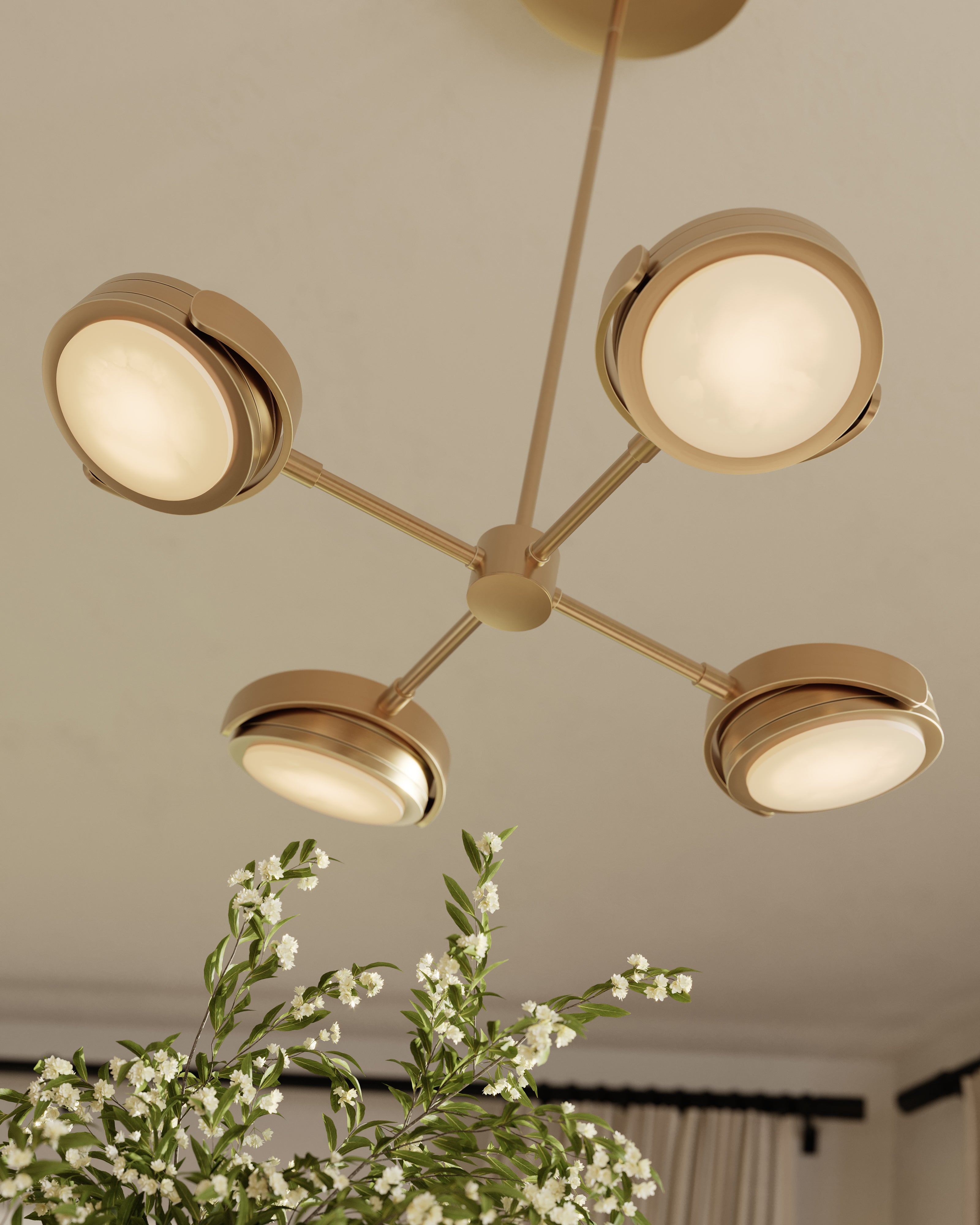 Modern LED pendant light with brushed gold finish, four adjustable round light heads, and floral arrangement.