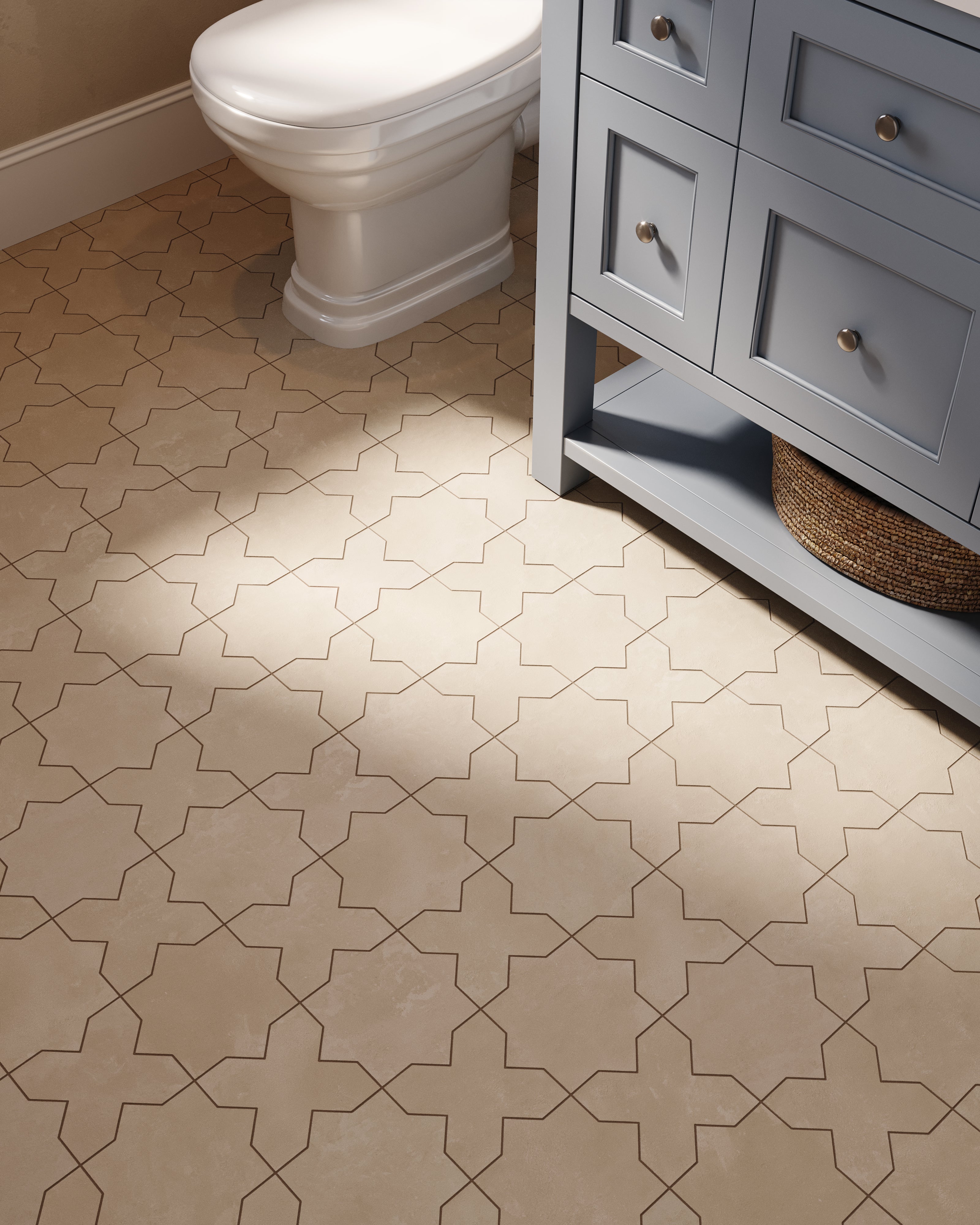 At the vanity and toilet area, grayish-beige star and cross 11x11 matte porcelain tile pairs with painted cabinetry, using cement-plaster texture and a powdery glaze.