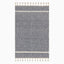 Boho-inspired hand loomed wool area rug with a navy and white geometric diamond pattern and tassel fringe, blending style and texture.