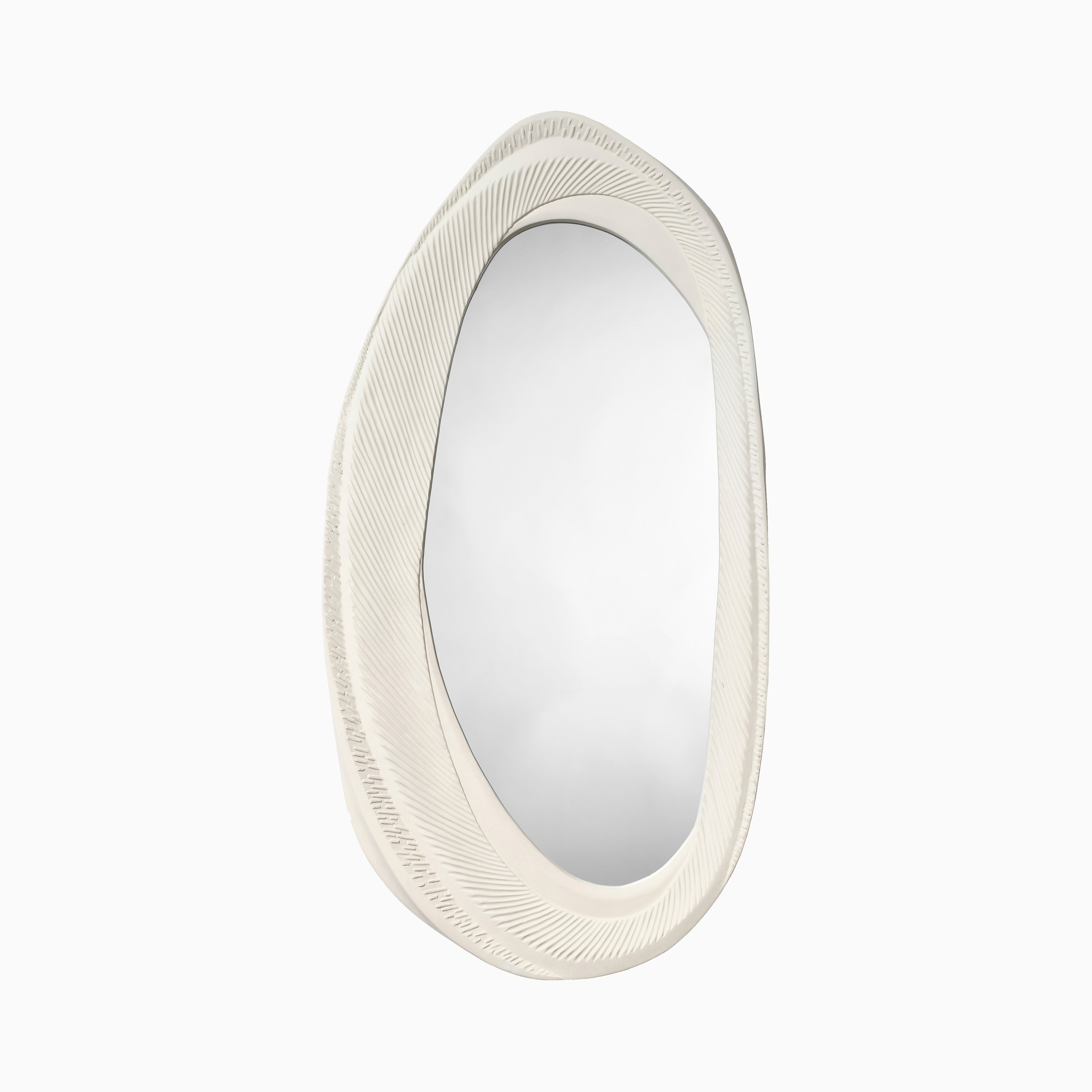Organic oval wall mirror with a softly contoured white resin frame, featuring flowing lines and a tactile finish inspired by coastal sand patterns.