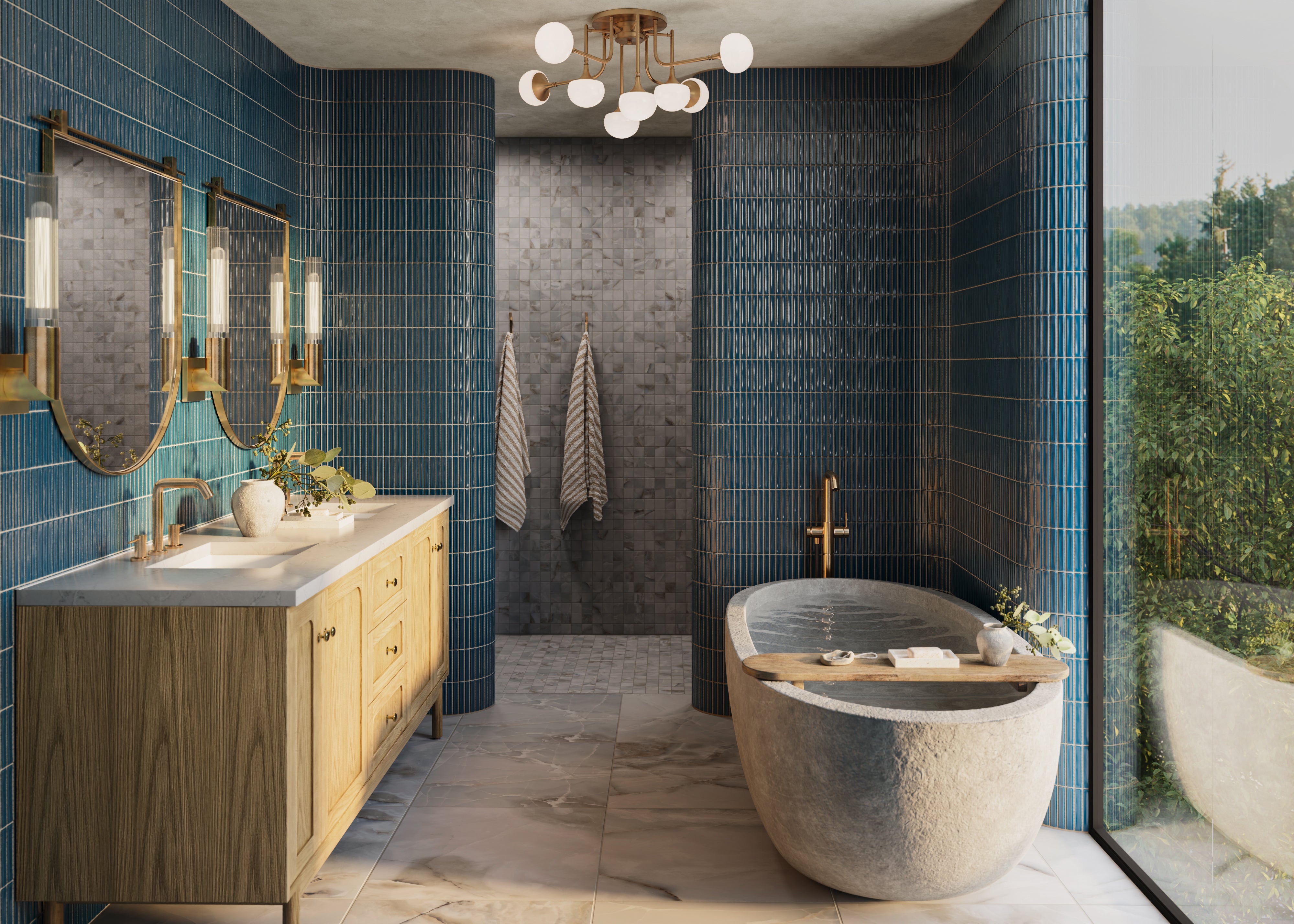 Spa-like bathroom with glossy blue kitkat mosaic-look tile covering the walls and curved shower partitions, featuring a light wood double vanity, brass-framed mirrors, a freestanding stone bathtub, gray mosaic shower tile, marble-look flooring, and a large window overlooking greenery.