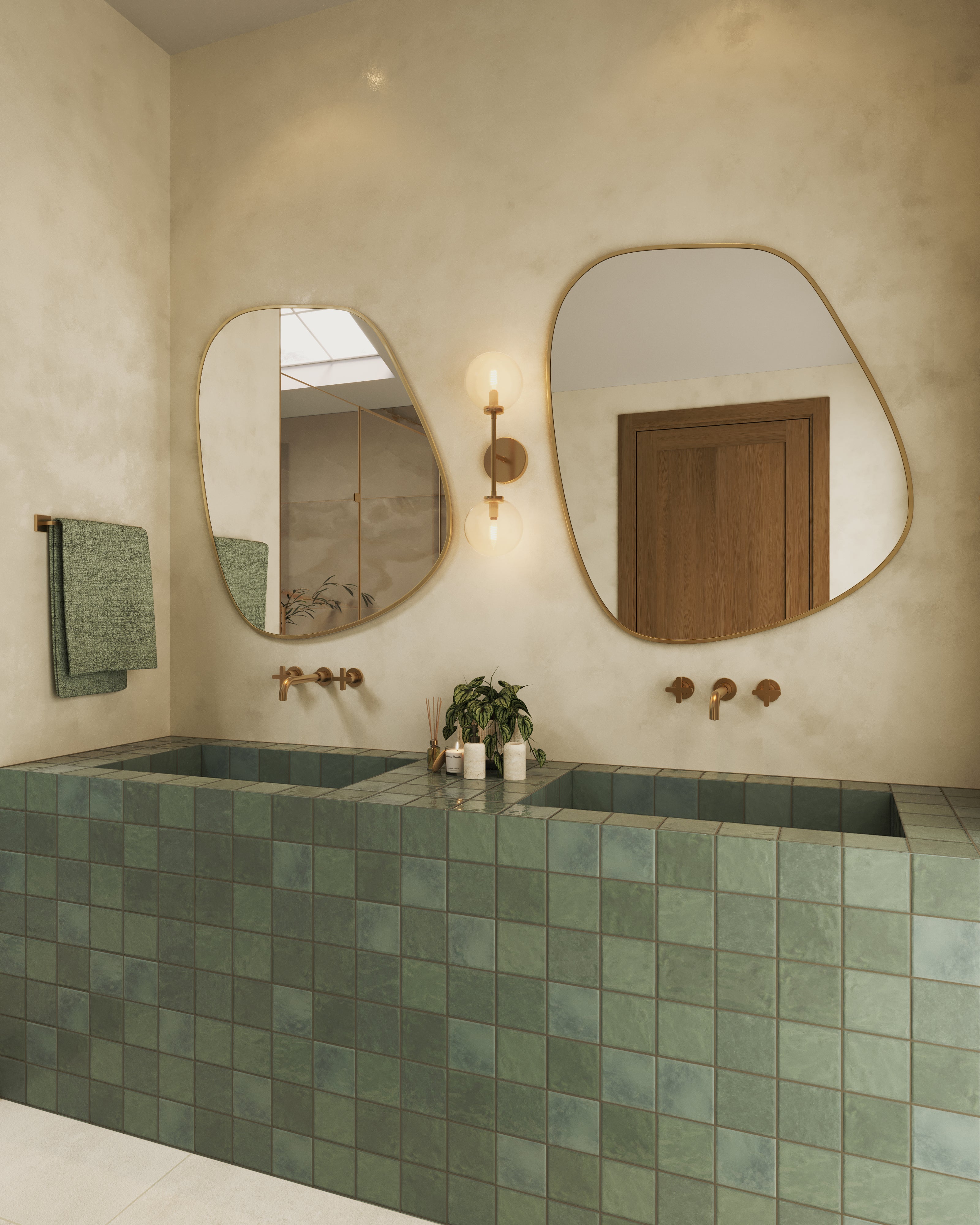 Modern bathroom with double green square tile sinks, asymmetrical mirrors, brass faucets, and globe wall sconce.