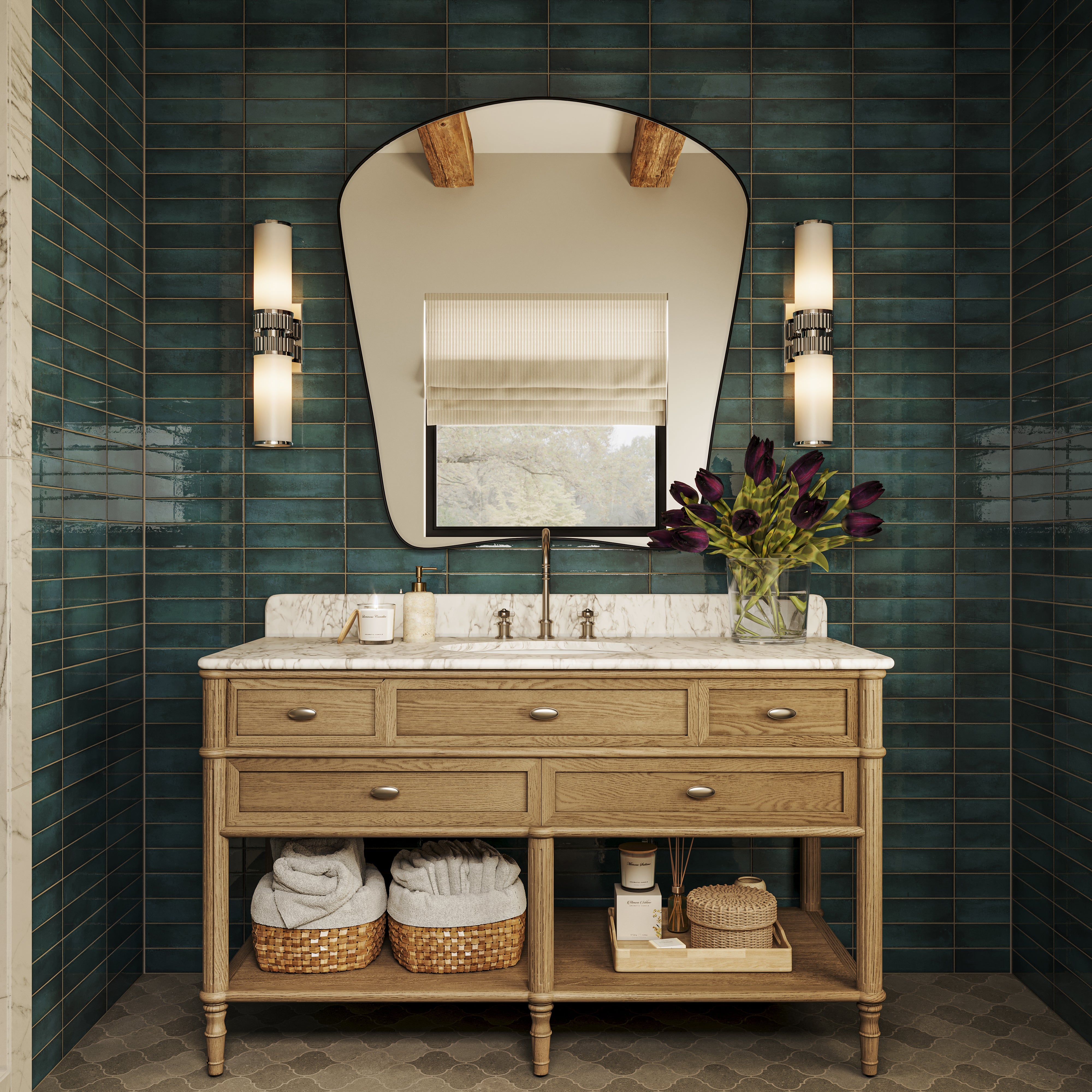Wood bathroom vanity with marble countertop, glossy blue-green tiled walls, large curved mirror, twin wall sconces, flower vase, and woven storage baskets.