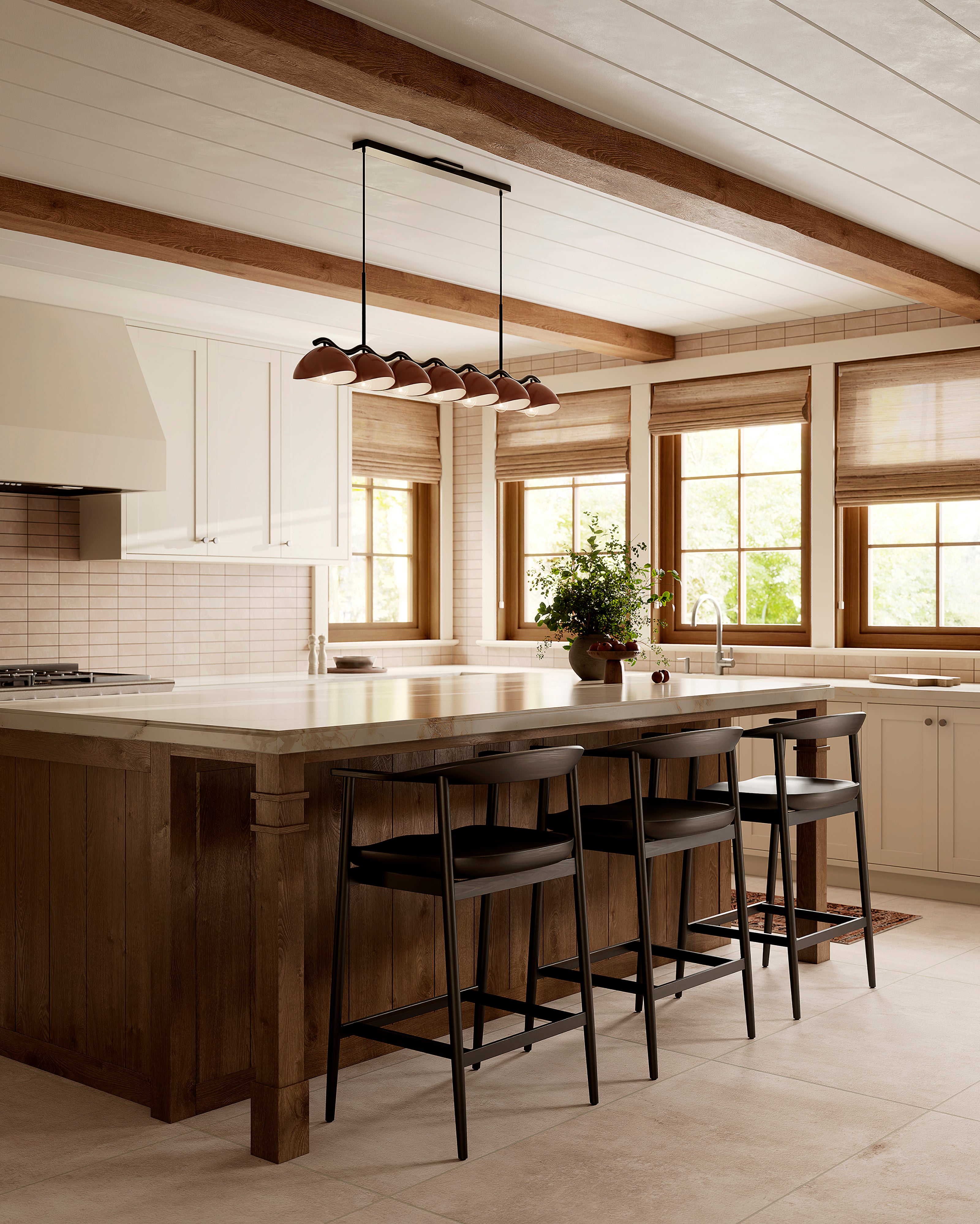 Bright kitchen with beige subway tile backsplash, wood island with black counter stools, and seven purplish, dark red dome linear pendant beneath exposed wood beams.